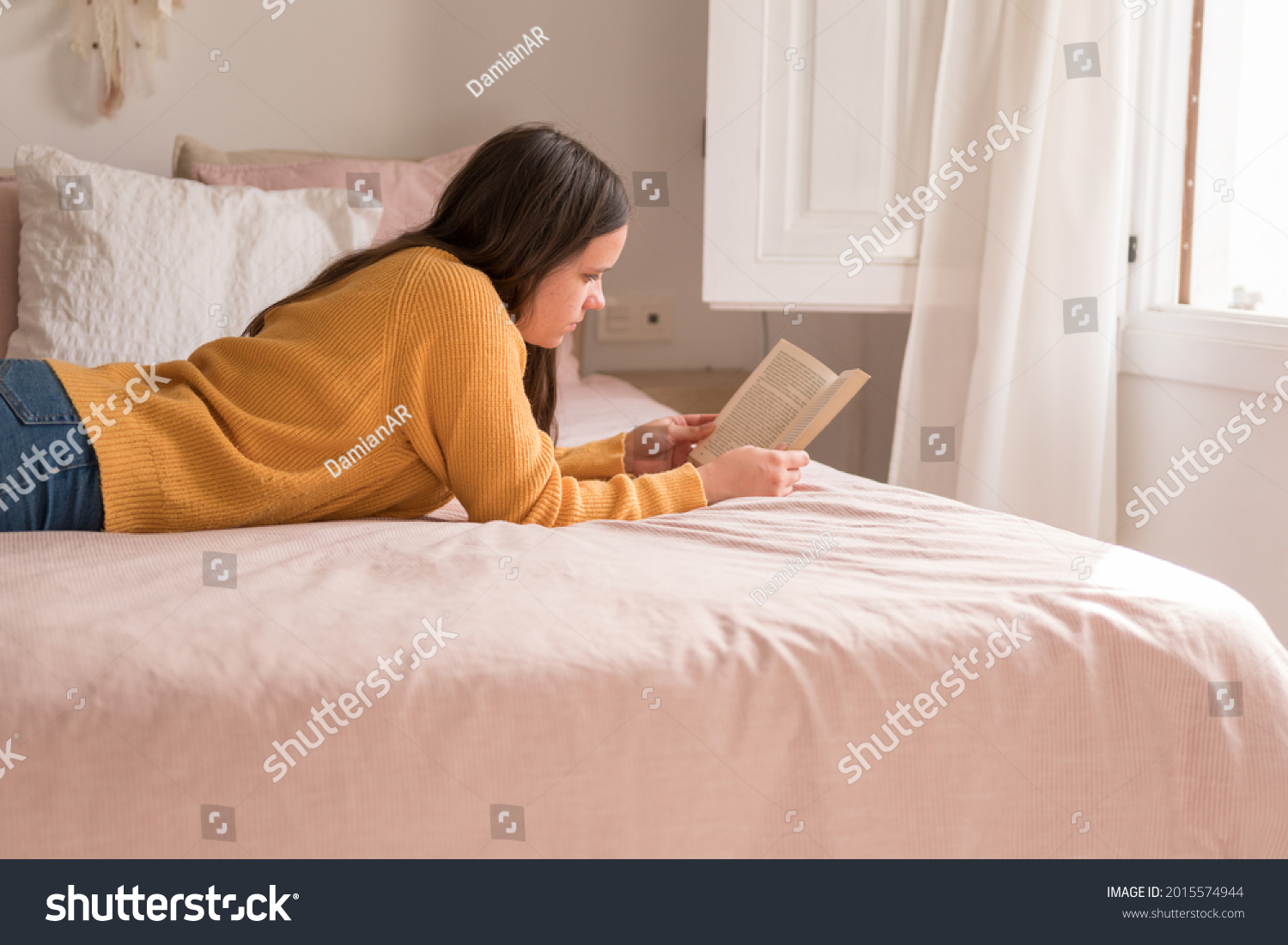girl reading lying in bed #2015574944