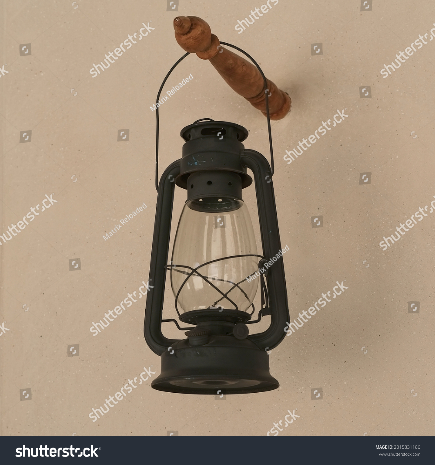 Vintage black gasoline lantern hanging on stucco wall background after renovation . Antique obsolete repaired kerosene lamp close up. Old oil lamp #2015831186