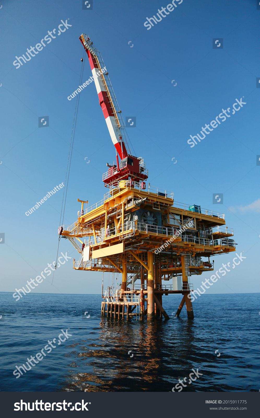 Oil and gas platform standing in the gulf or offshore and operation by technician. Crane moving any cargo or tools basket from supply boat to the platform. Heavy lift was moving by crane technician. #2015911775