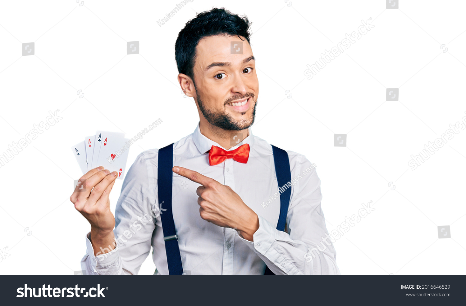 Hispanic man with beard holding poker cards smiling happy pointing with hand and finger  #2016646529