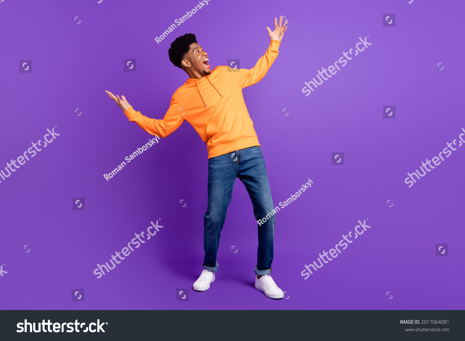 Full body photo of positive young dark skin man look empty space hands amazed isolated on violet color background #2017064081