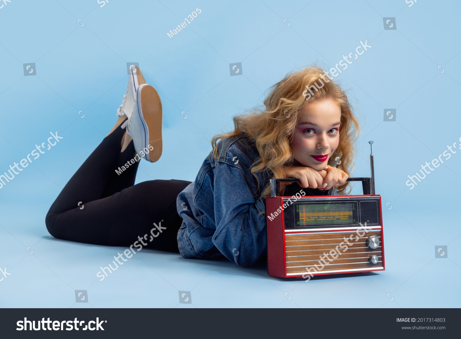 Disco, party time. Portrait of attractive woman in retro 90s fashion style, outfit isolated over blue studio background. Concept of eras comparison, beauty, fashion and youth. #2017314803