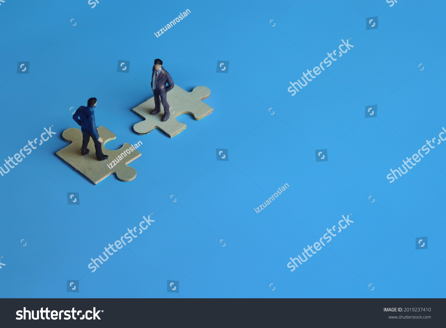 Business mergers and acquisitions, partnership concept. Two miniature people merging on puzzle. Copy space for text #2019237410