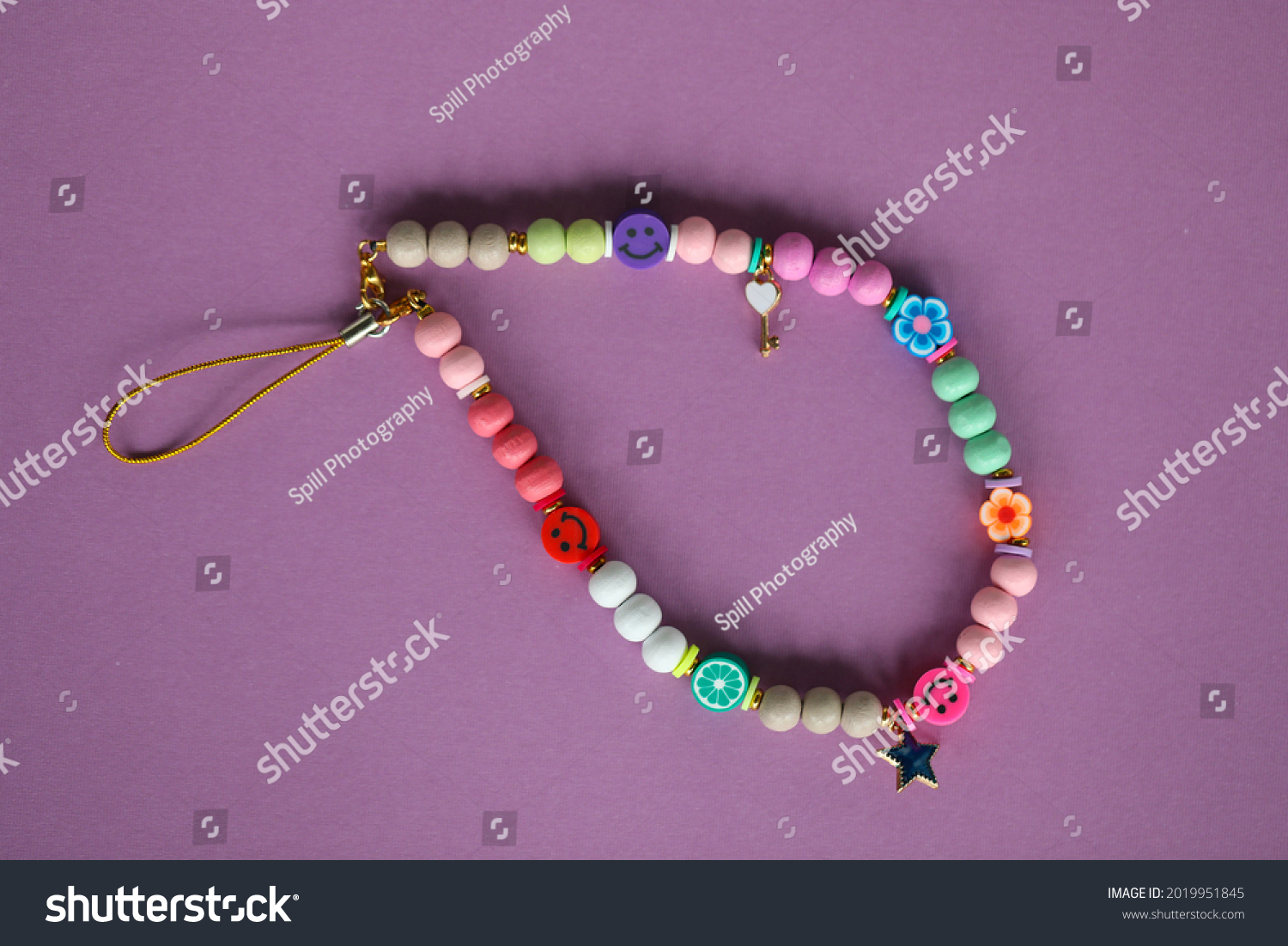 A cute phone charm made with wooden beads and charms.  #2019951845