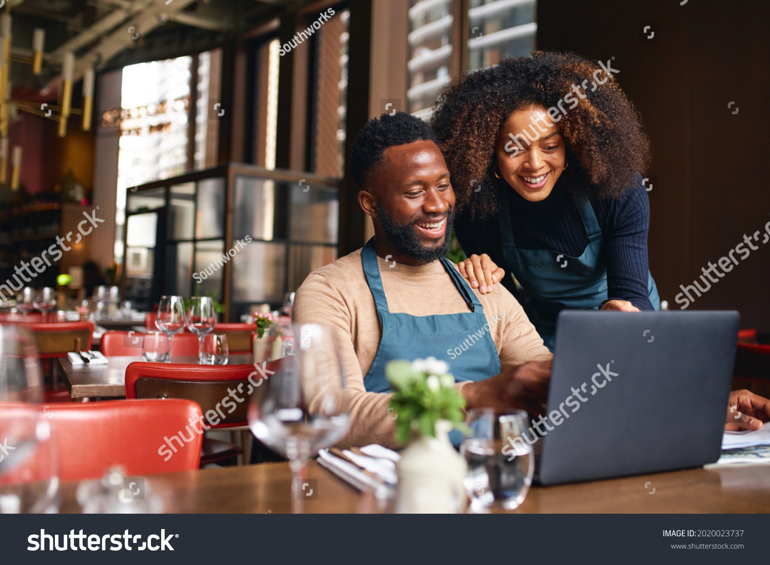Small business owners using laptop in restaurant #2020023737