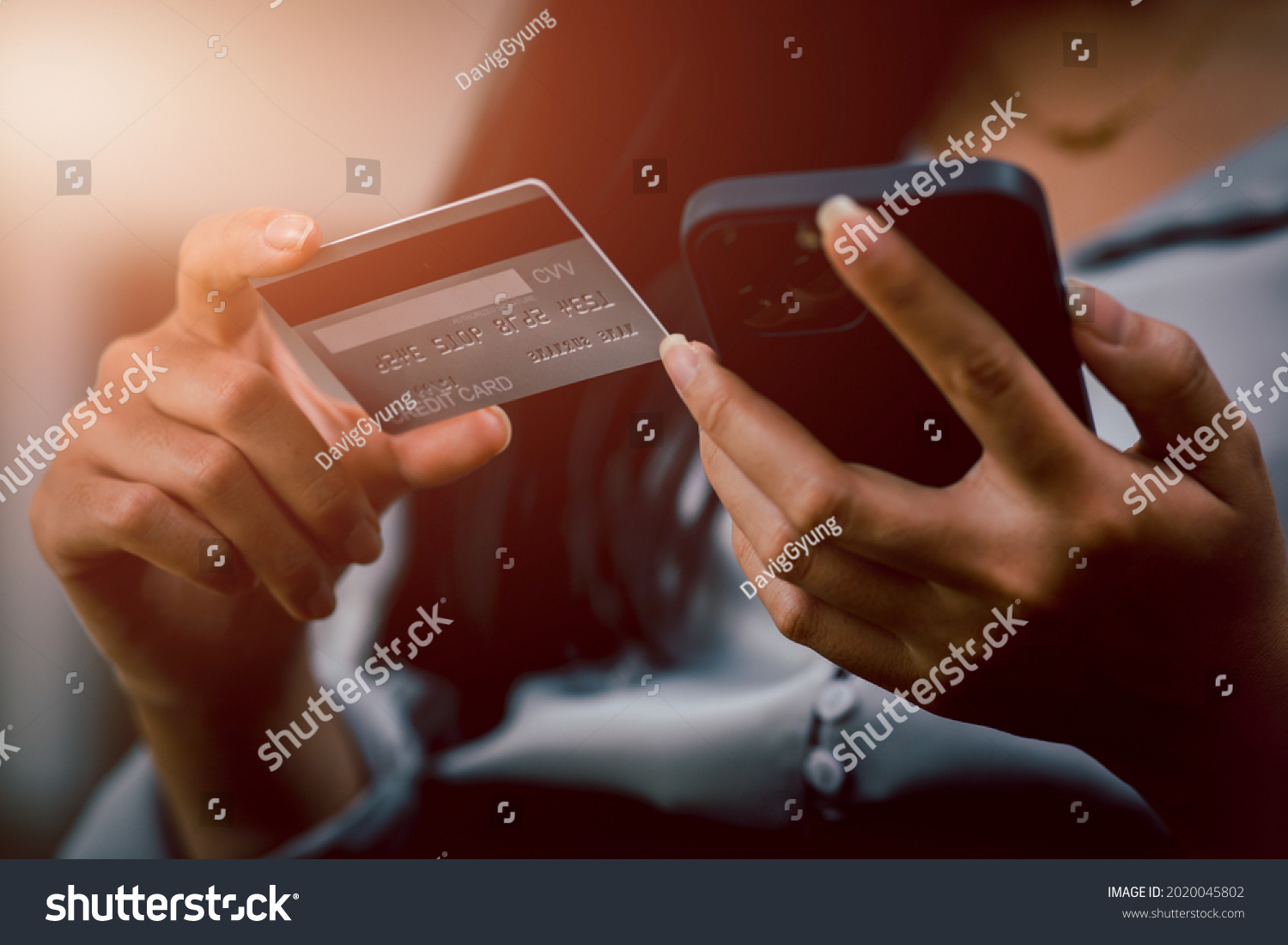 Close up woman hand using credit card and smartphone for buying online shopping,online payment, shopping online, e-commerce, internet banking, spending money. #2020045802
