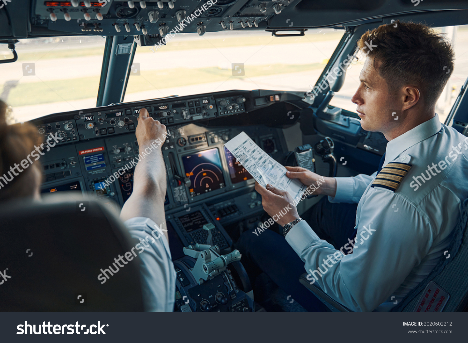 Airline captain and first officer sitting in the cockpit #2020602212