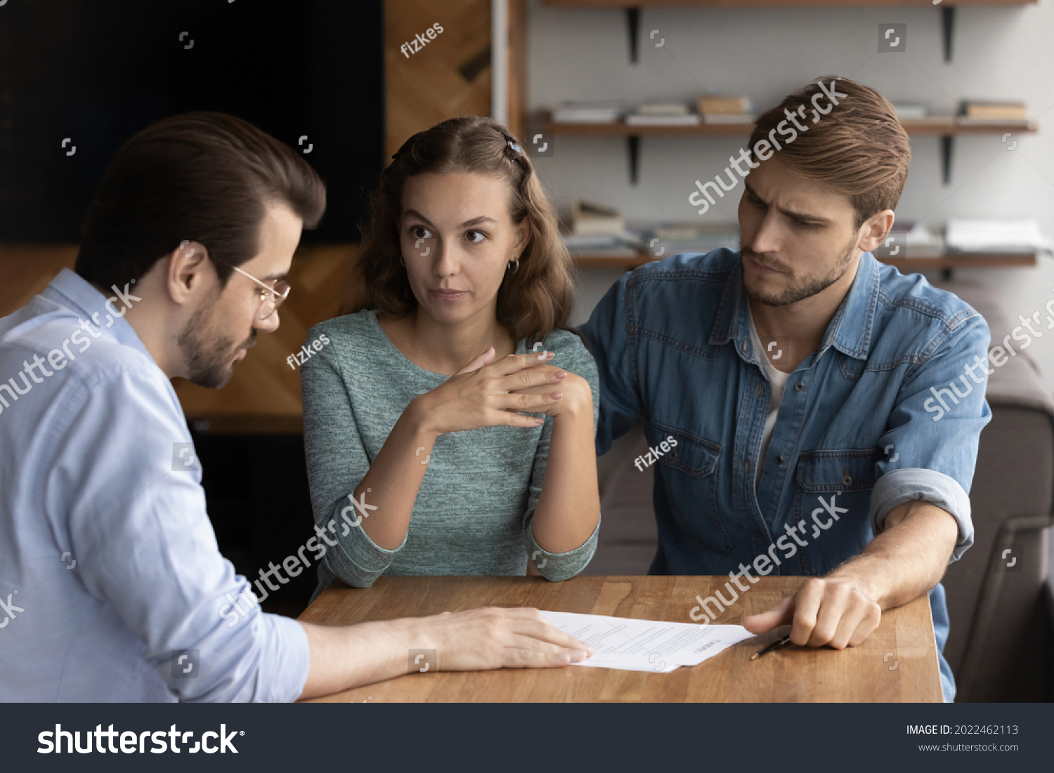 Couple of angry tenants having dispute with real estate agent, discussing complaint with lawyer, consulting legal expert about mistakes in document, wrong mortgage agreement. Cheated clients concept #2022462113