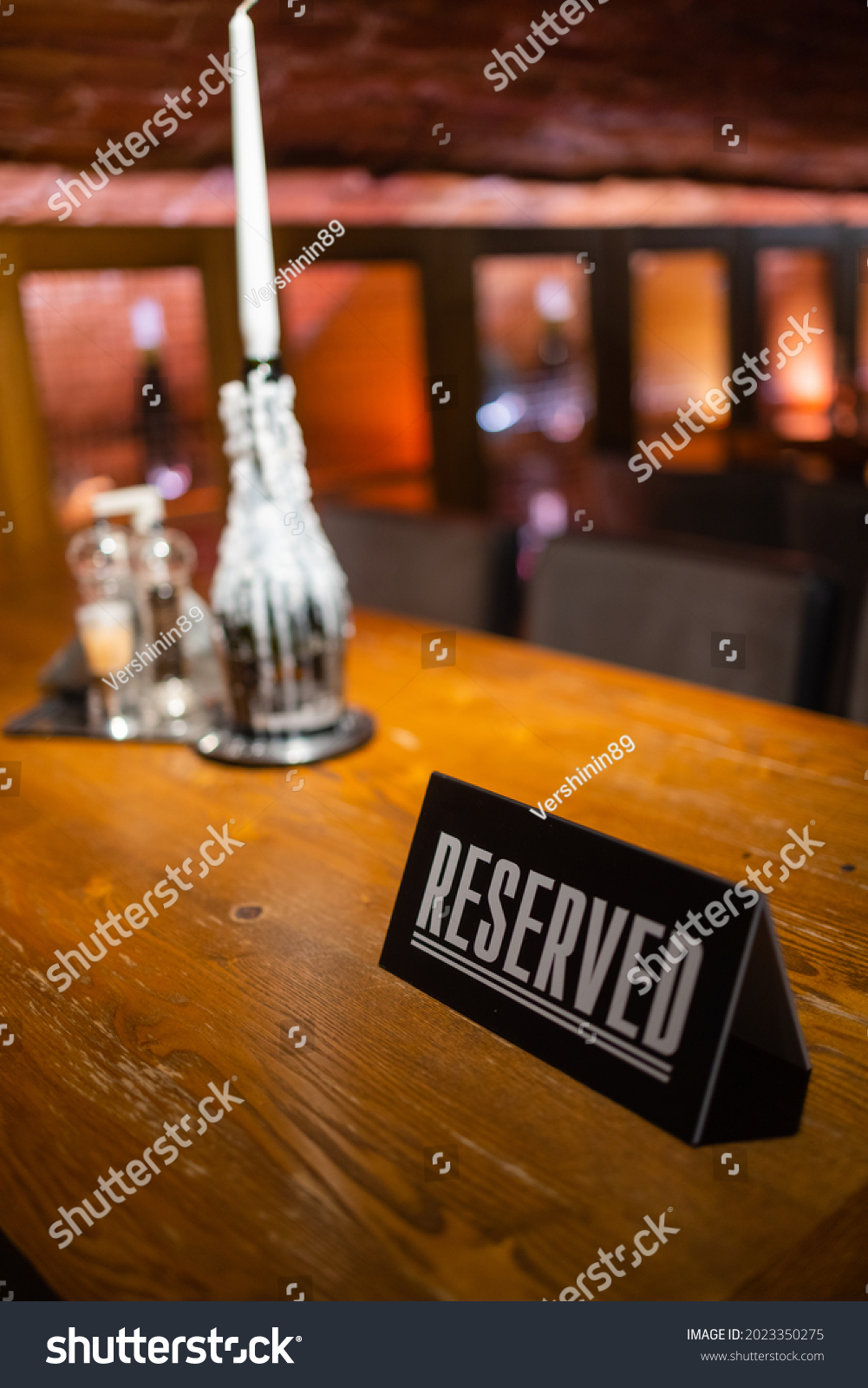 A modern idea for a reserved table with the inscription Reservation of your place. Idea restaurants the inscription reserved on a wooden table in a cafe. #2023350275