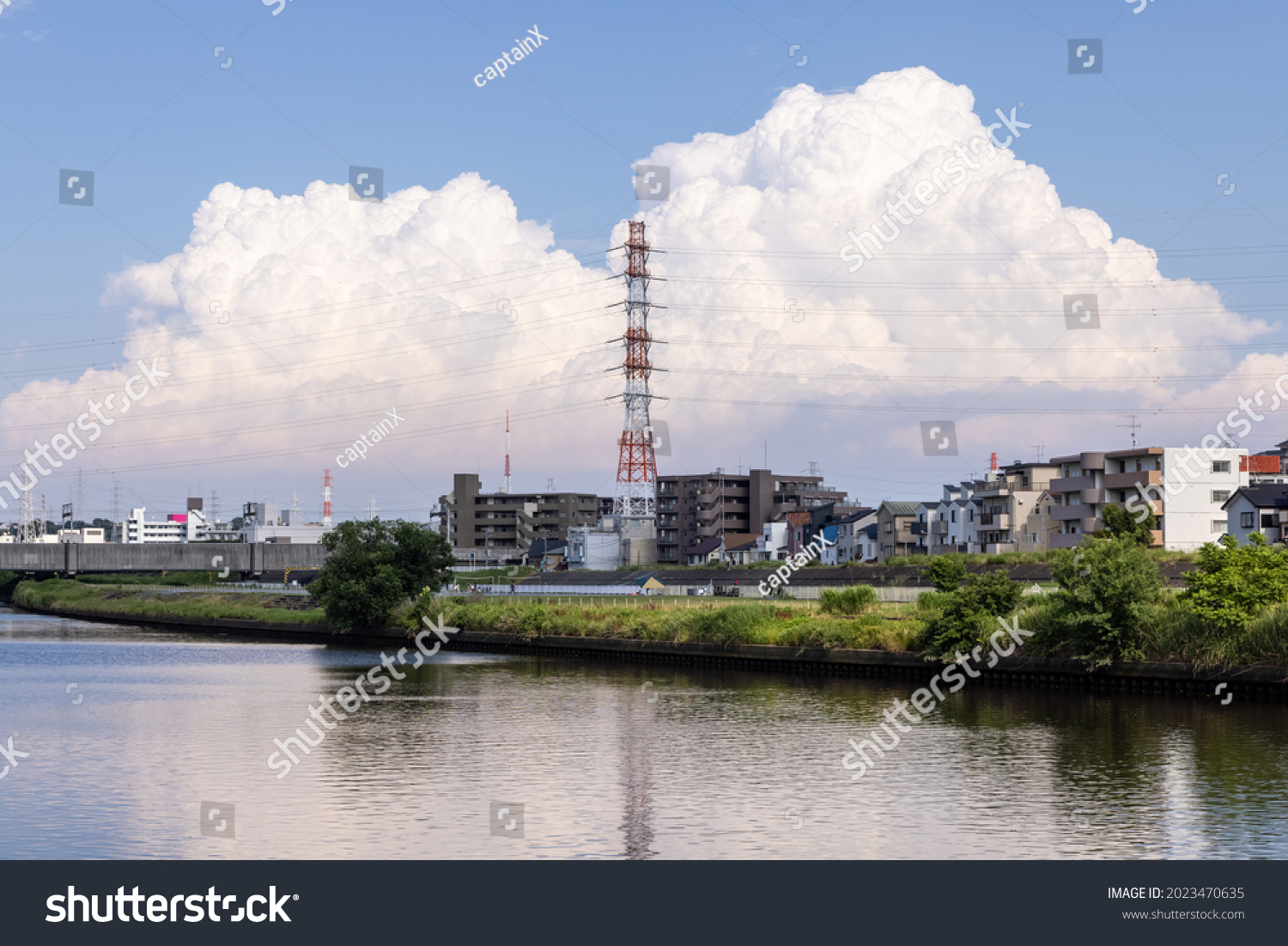 Cumulonimbus clouds that develop on summer days, river surface that reflects cumulonimbus clouds #2023470635