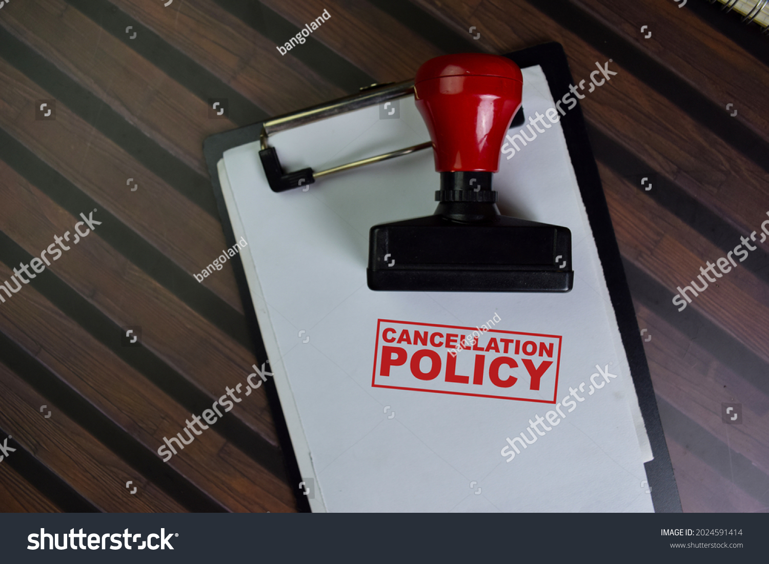 Red Handle Rubber Stamper and Cancellation Policy text isolated on wooden table. #2024591414