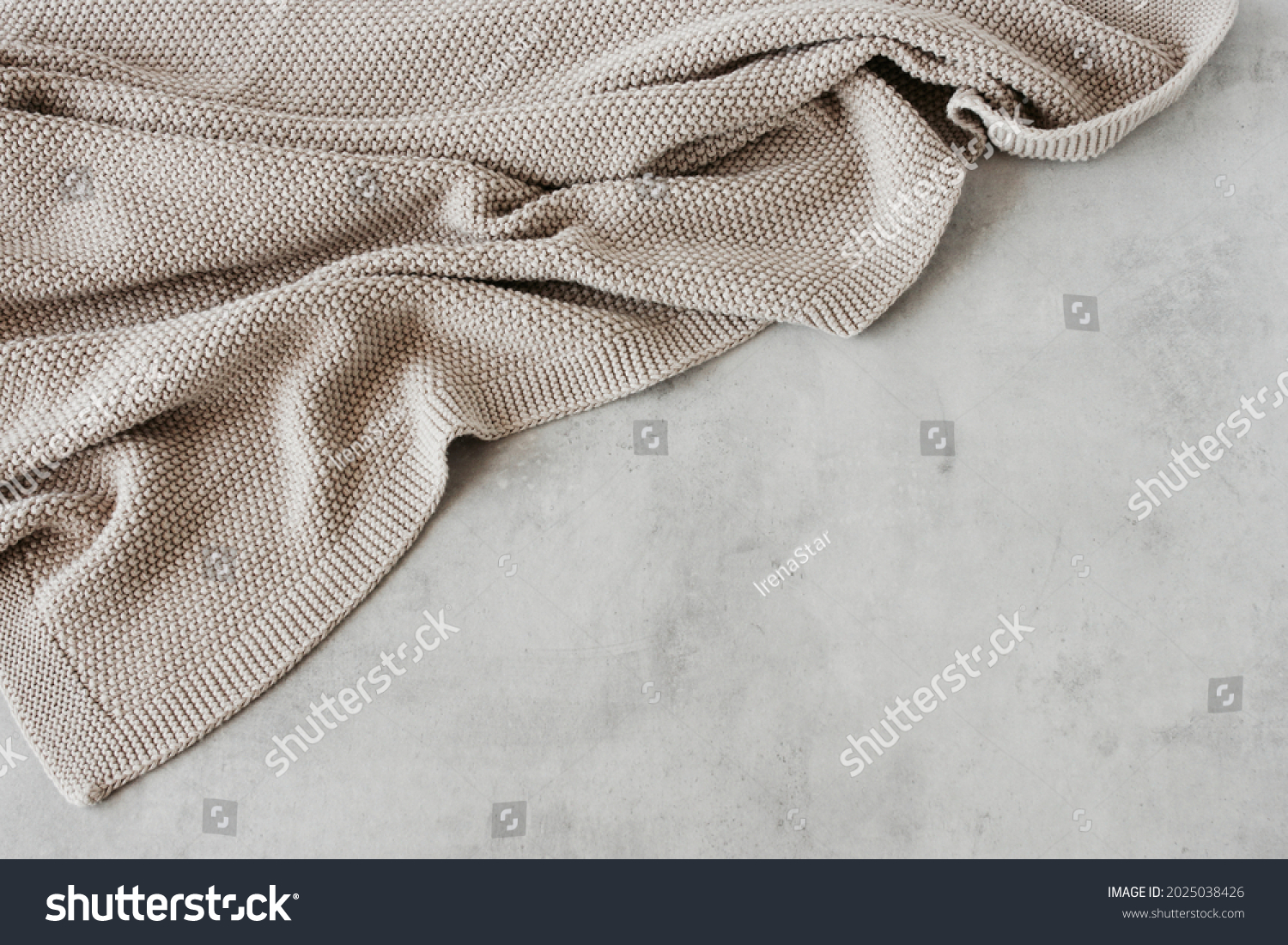 Beige knitted blanket on gray concrete background with copy space.Autumn, winter  concept.Flat lay, top view #2025038426