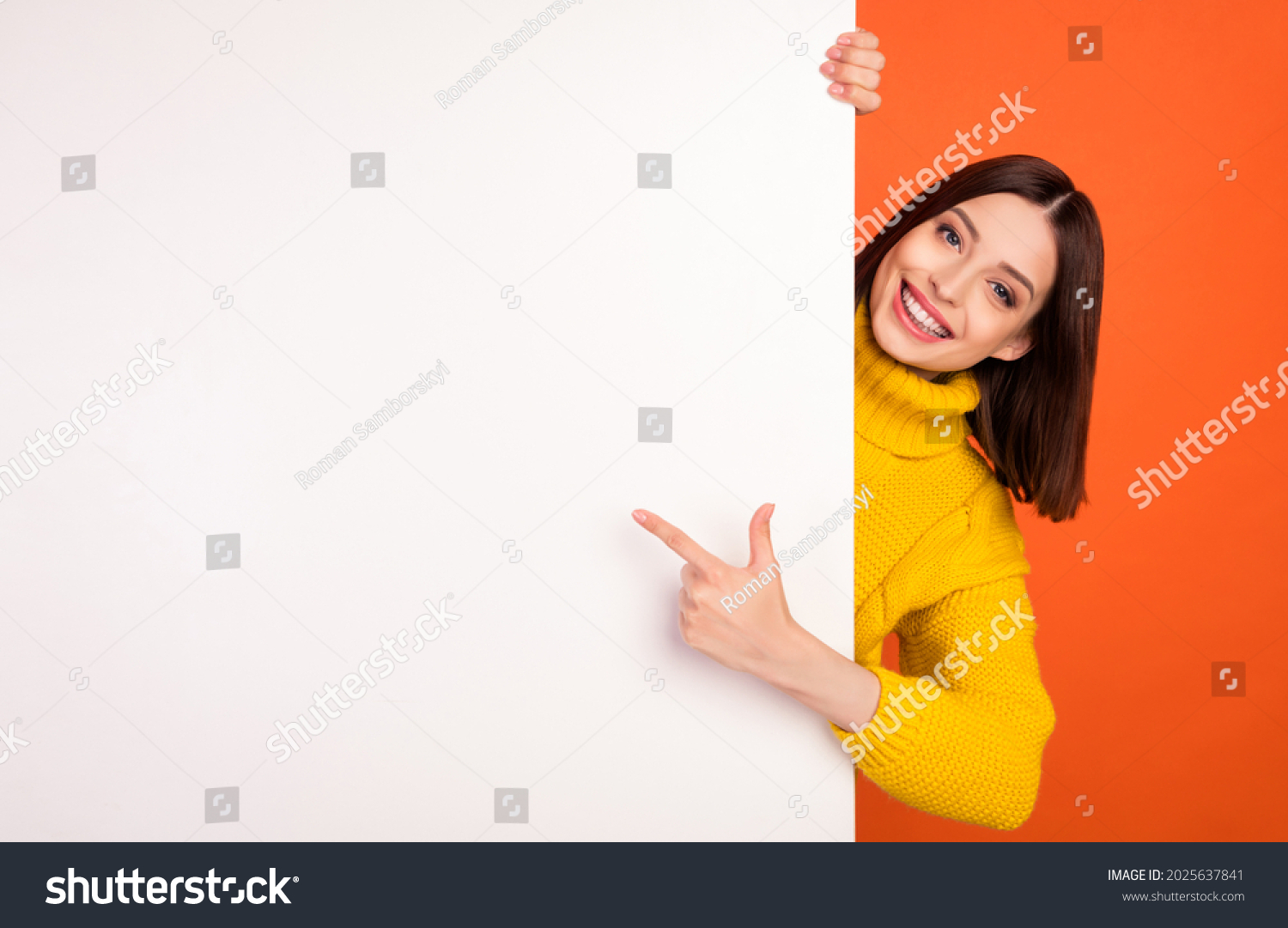 Photo of young woman happy positive smile point finger empty space billboard ad advice choice isolated over orange color background #2025637841