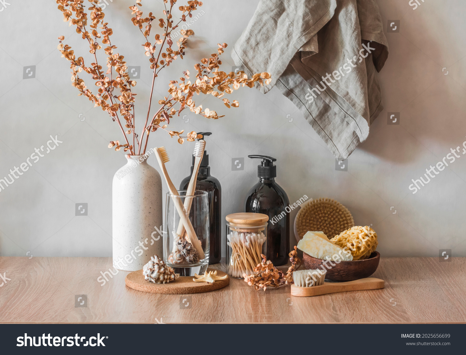 Bathroom interior still life. Decorative flowers, shampoo bottles, cotton buds, brushes, soap, towels on a wooden background. Minimalism interior       #2025656699