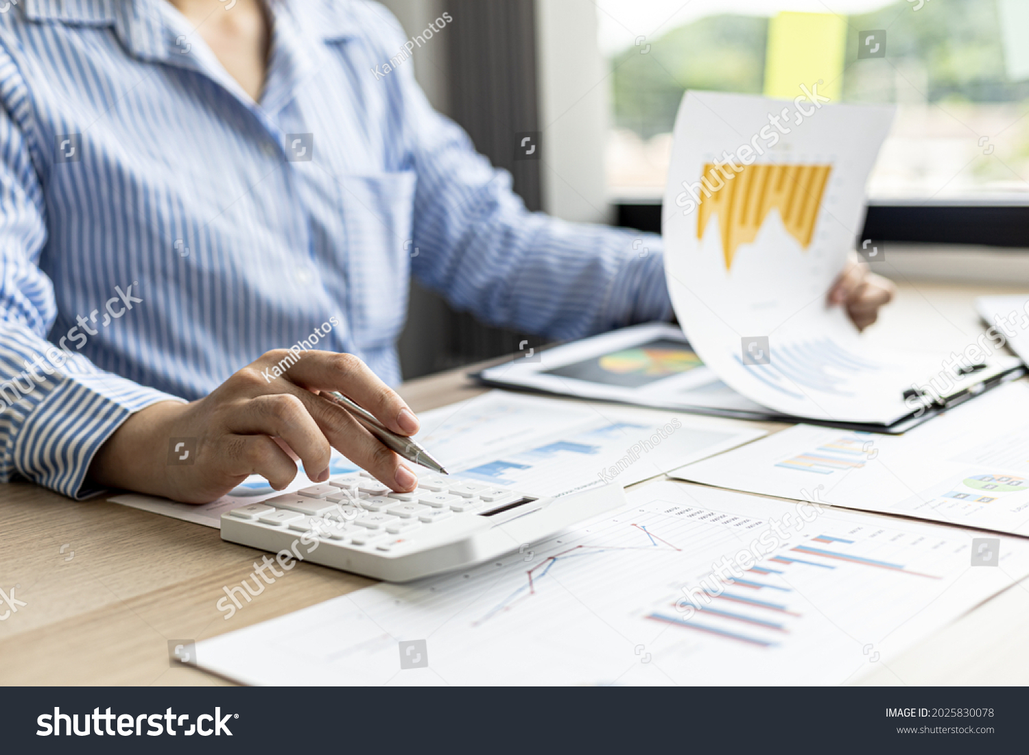 A female financier is reviewing company financial documents, monthly financial statement summary from the finance department. The concept of managing the company's finances for accuracy and growth. #2025830078