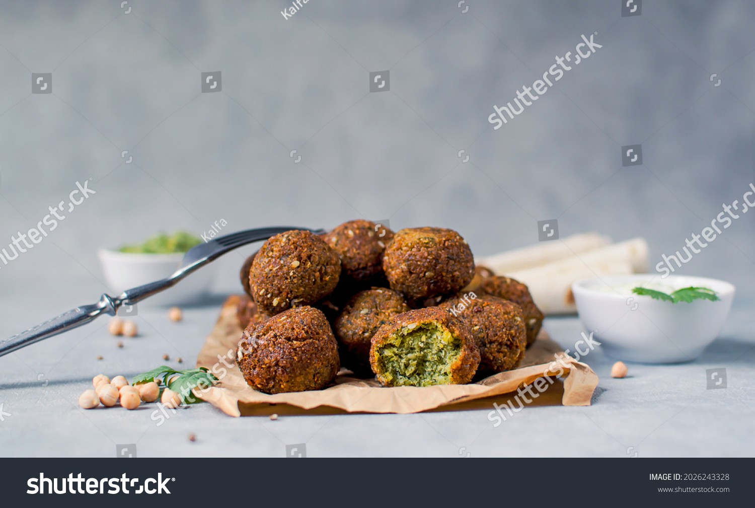 Fresh falafel balls on a black gray background with yoghurt sauce. Vegetarian food, diet, proper nutrition. #2026243328