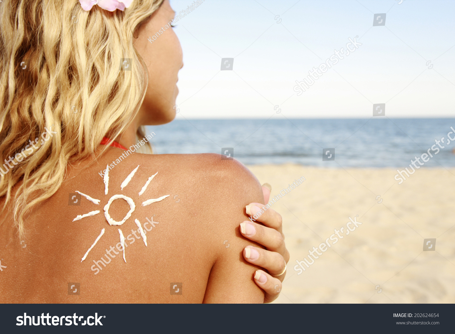 a of sun cream on the female back on the beach  #202624654