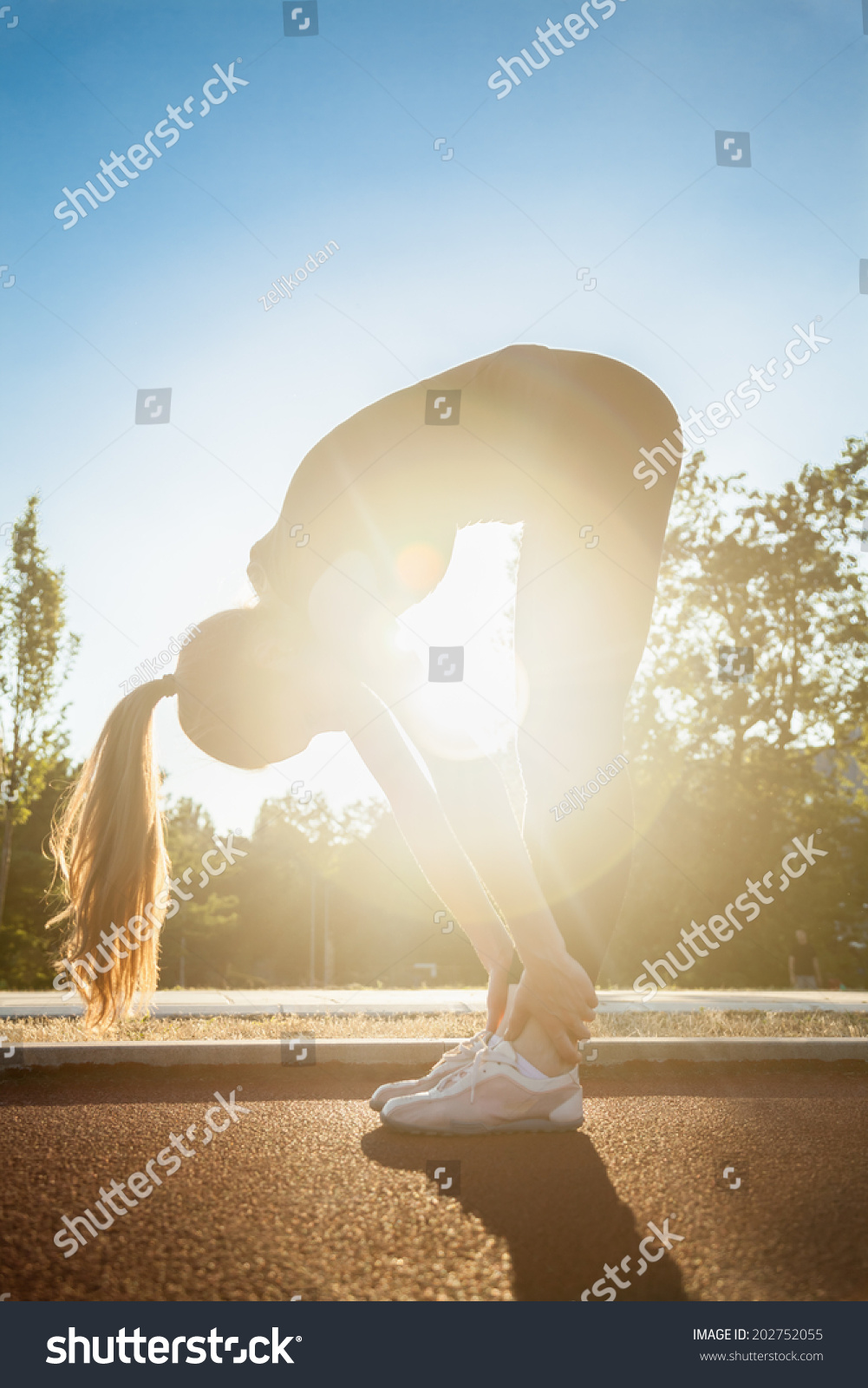 An Attractive Female Runner Stretching Before Workout #202752055