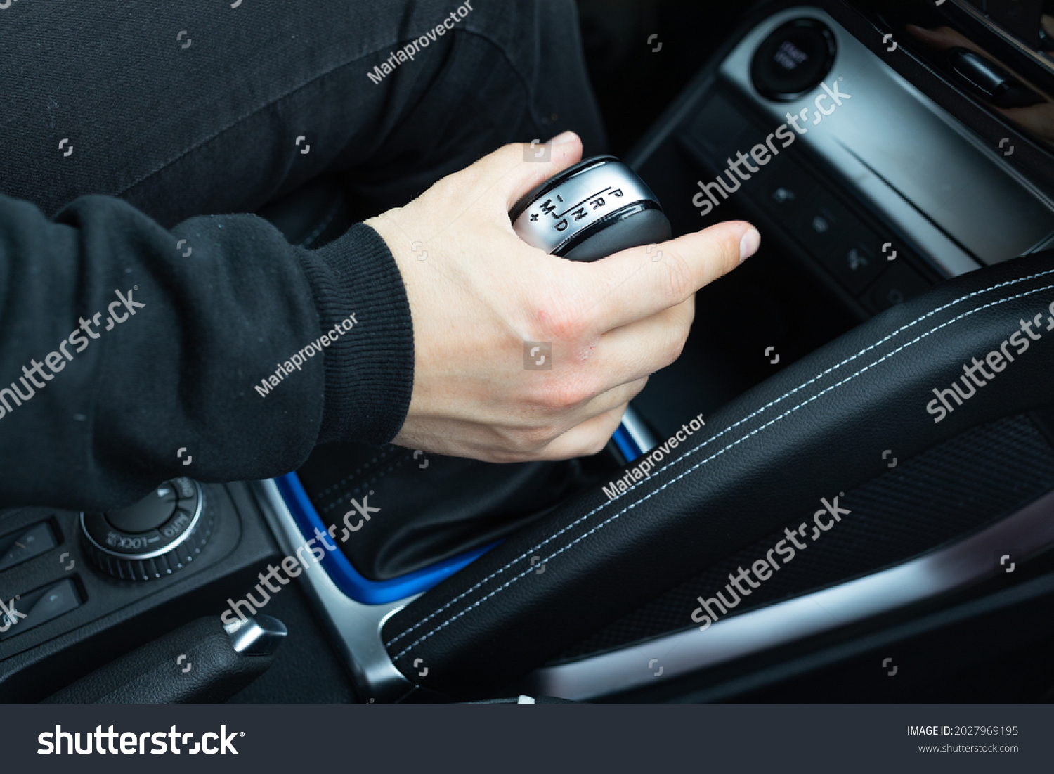male hand shifts gears on the automatic transmission lever #2027969195