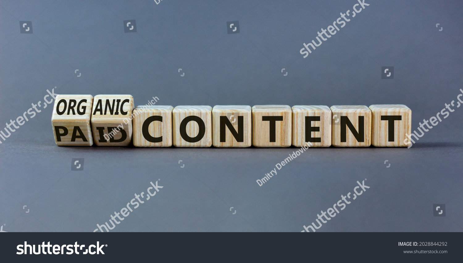Paid or organic content symbol. Turned wooden cubes and changed words 'paid content' to 'organic content'. Beautiful grey table, grey background, copy space. Business, paid or organic content concept. #2028844292