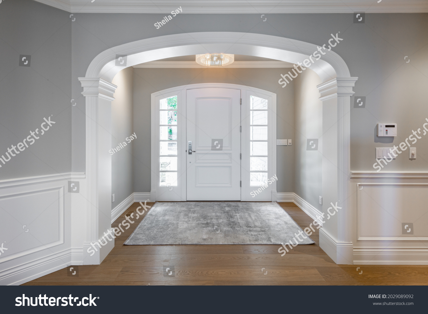 Grand foyer with white doors and elegant staircase and wraught iron #2029089092