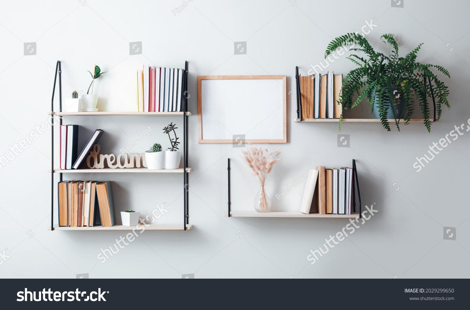 Shelves with books and decor hanging on light wall #2029299650