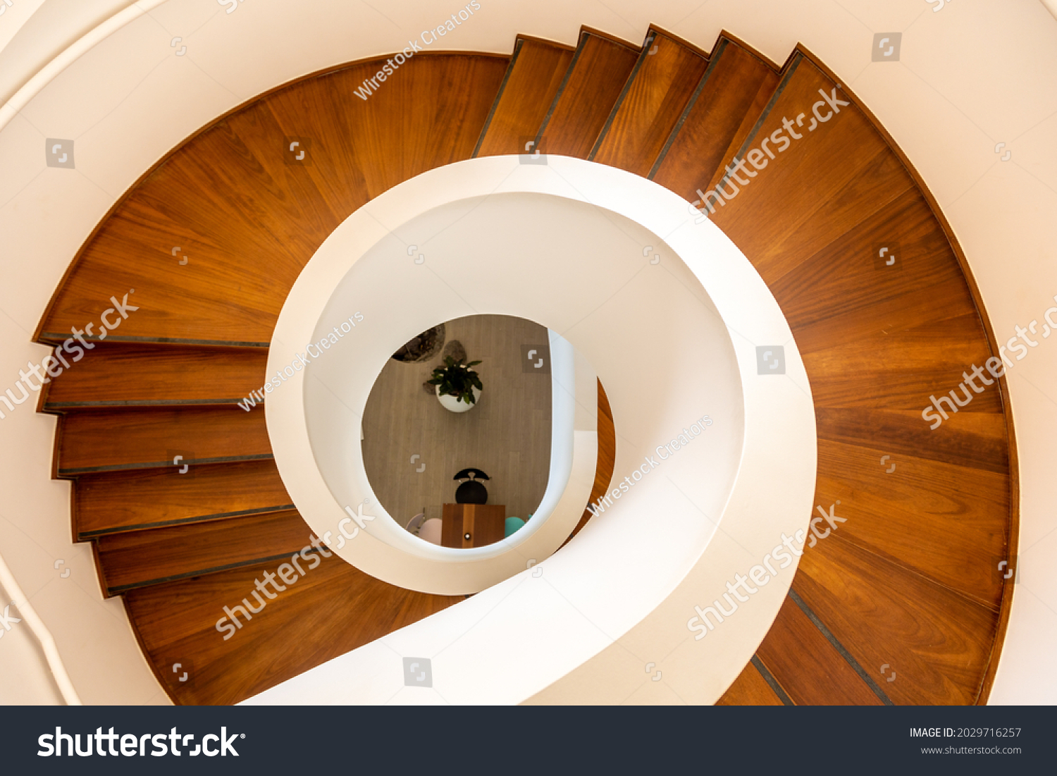 A top view of a wooden spiral staircase in a private house #2029716257