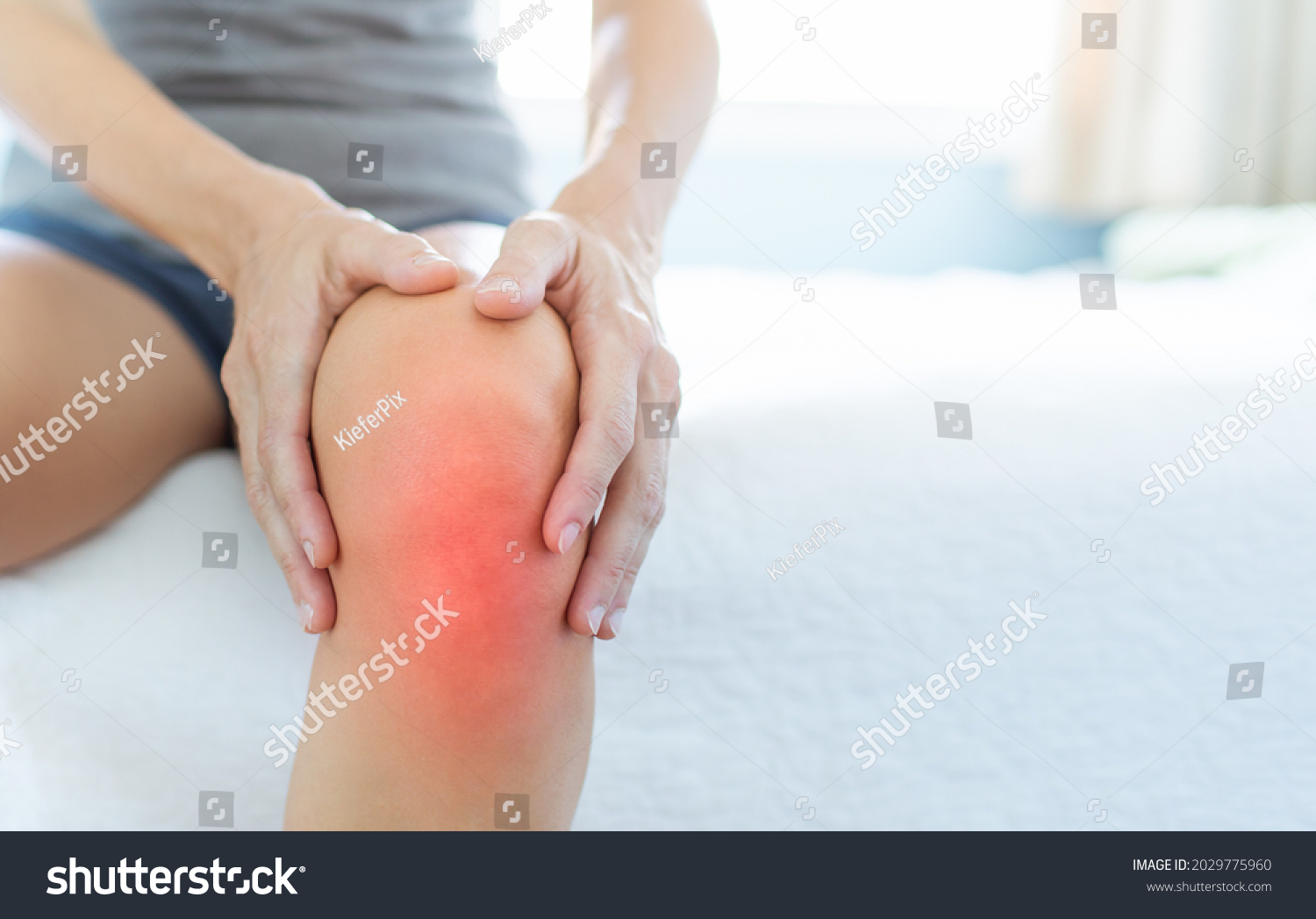 Mature woman massaging painful knee, joint inflammation arthritis problems. Woman suffering from knee pain at home, closeup.  #2029775960