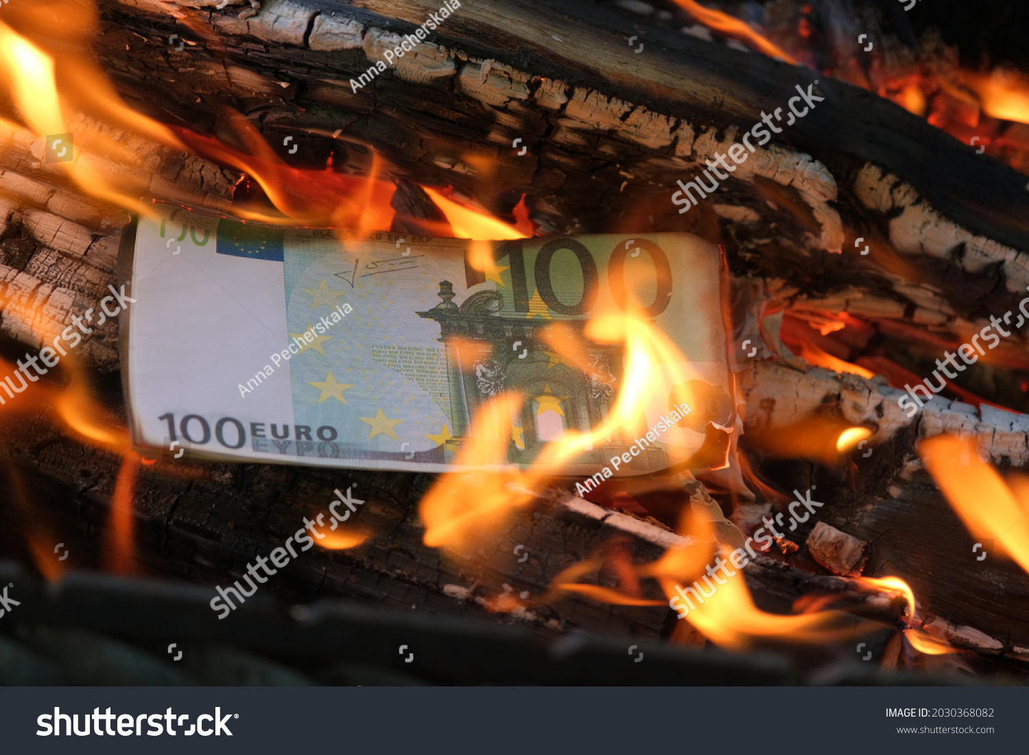 a 100 euro banknote is burning in a flame of fire. Close-up, horizontal photo. Concept - crisis, default, economic decline. #2030368082