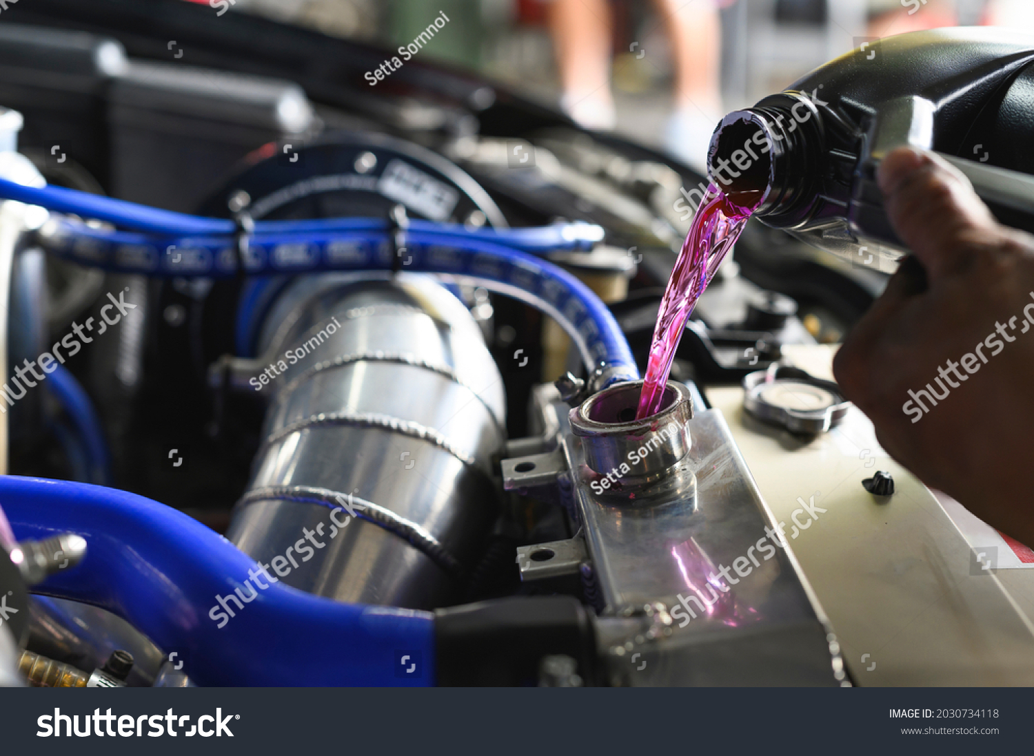 Auto mechanic filling Pre-mixed Super Long Life Coolant fluid in aluminum car radiator fill hole.
 #2030734118