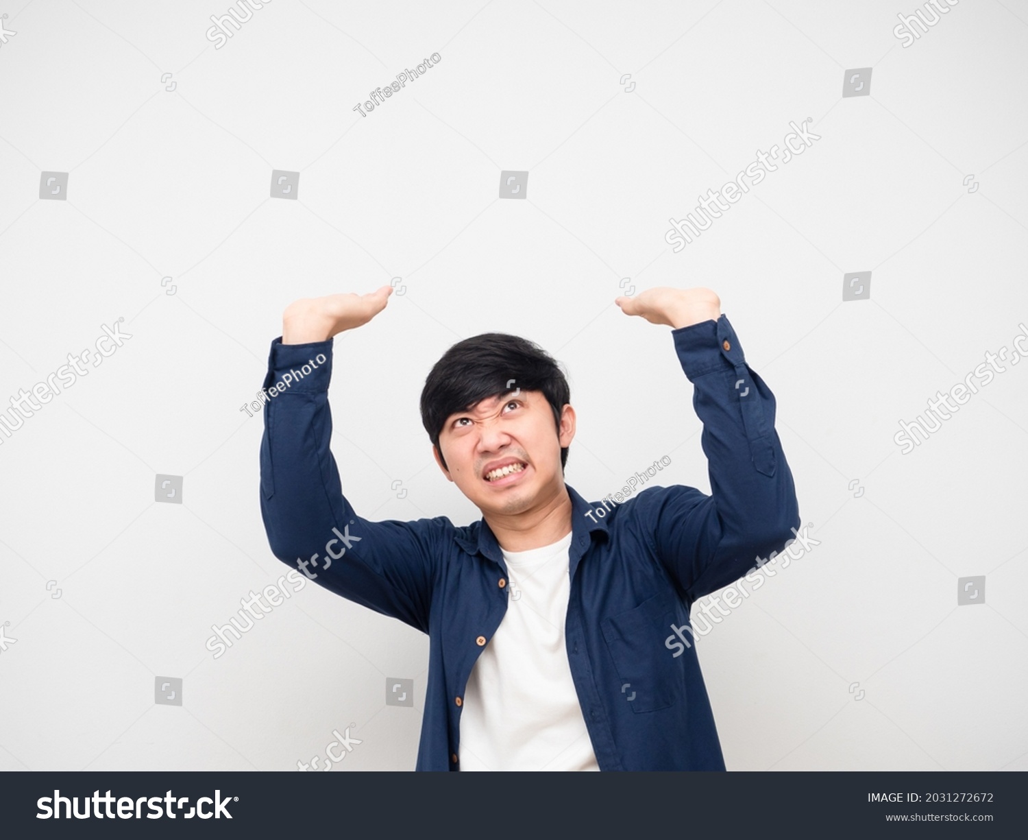 Asian man gesture carry something serious face,Asian man gesture carry product on his head white background #2031272672