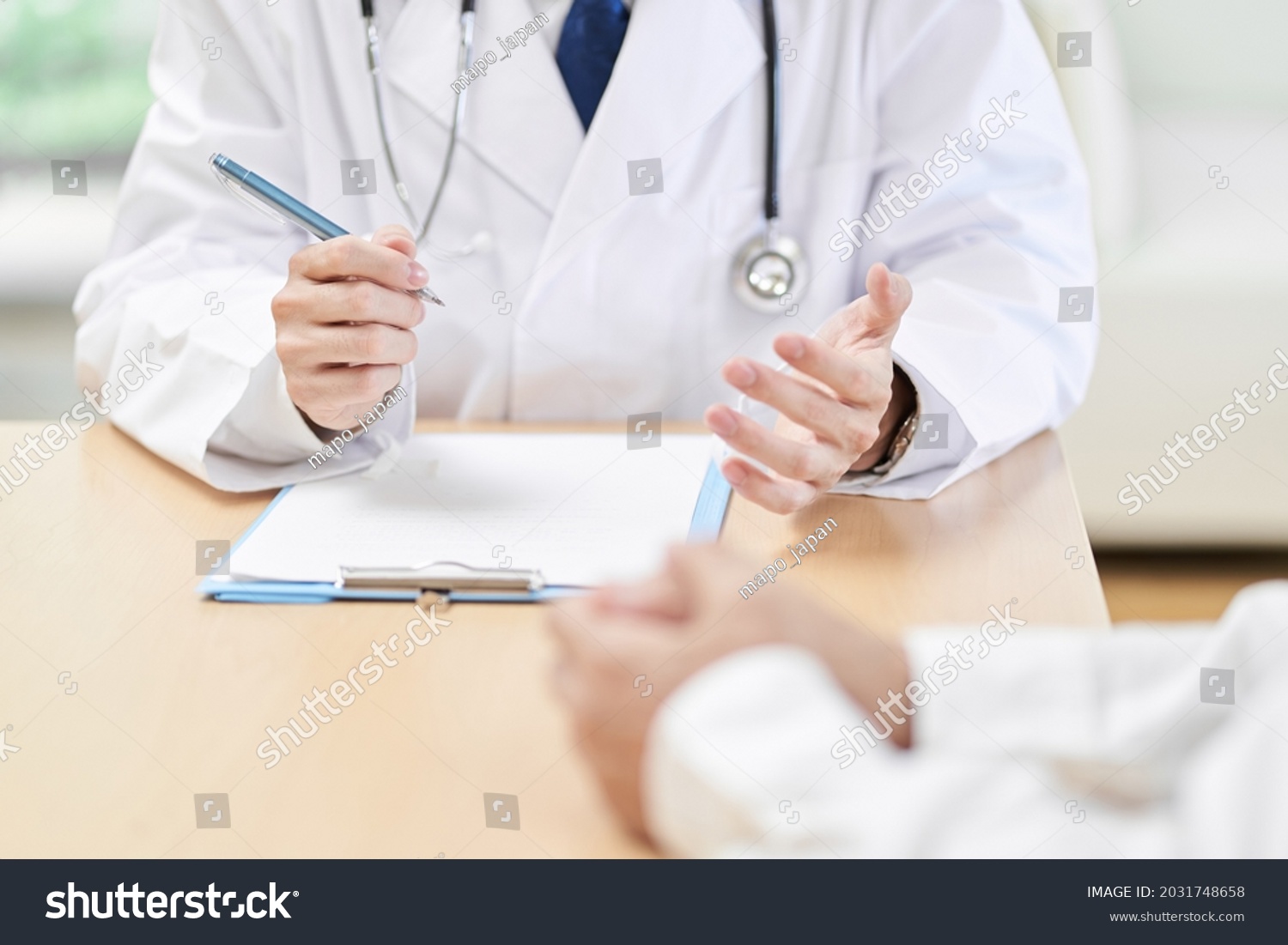 Hands of a male doctor explaining symptoms to the patient #2031748658