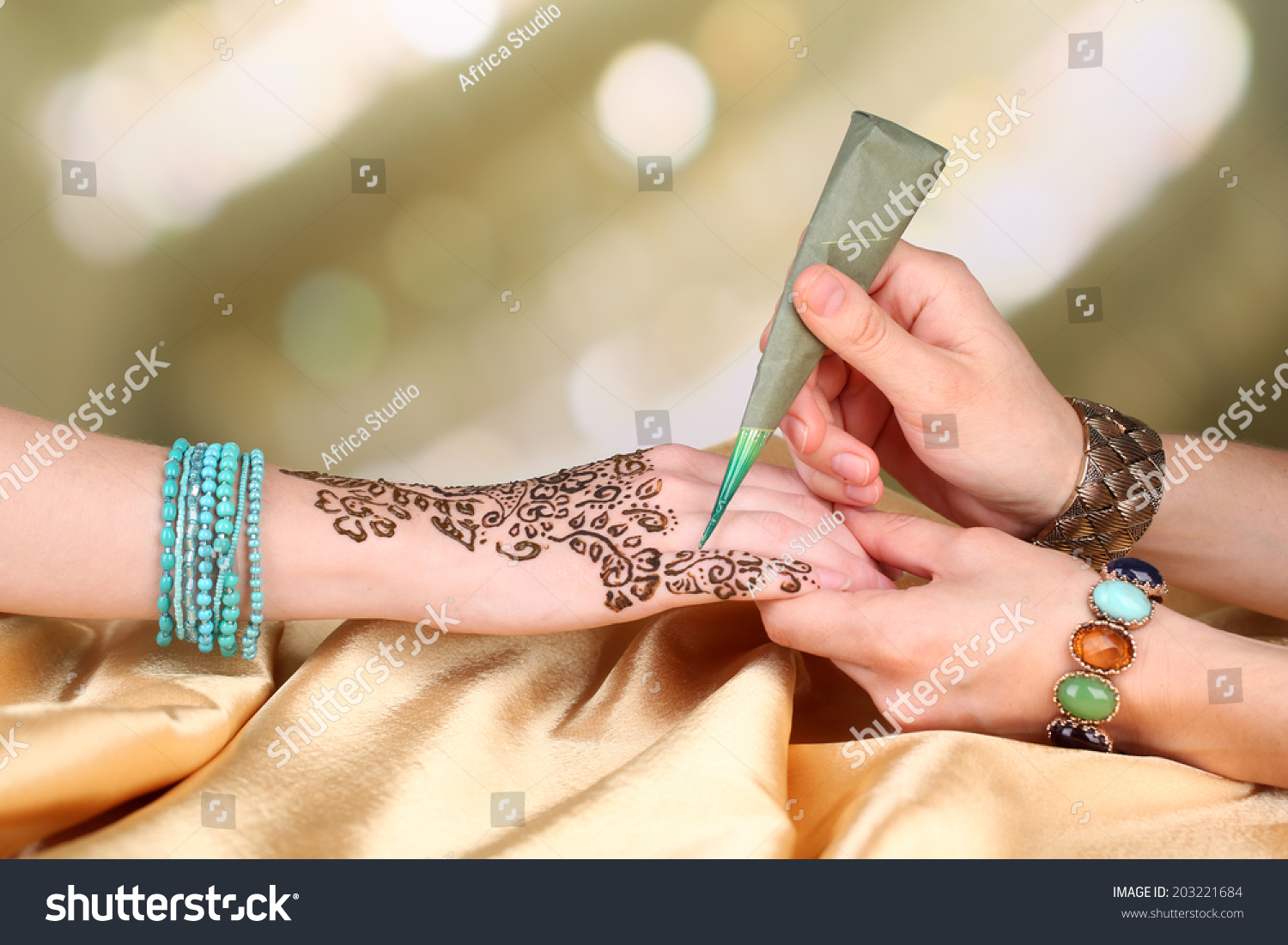 Process of applying Mehndi on female hand, close up #203221684