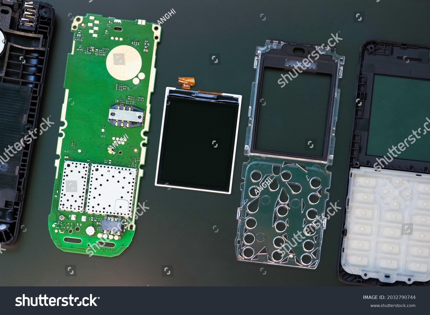 Disassembled push-button mobile phone. Details of telephone top view. Broken mobile phone and parts mobile disassembly #2032790744