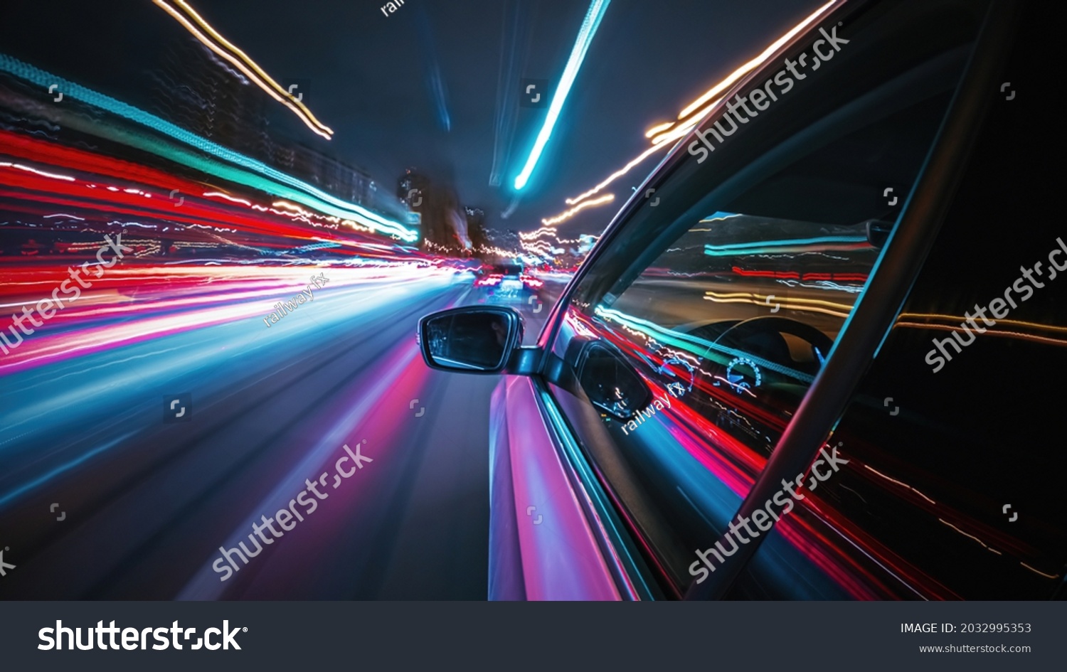 Motion time of a speedy night drive in a big city ending in the underground car parking. Side view from the car window to the road with light trails from vehicles and street lights. #2032995353
