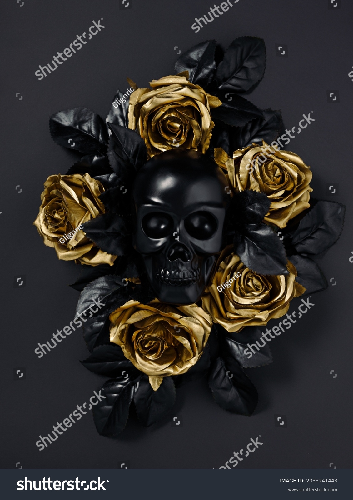 Black skull surrounded with golden rose flowers and black leaves isolated on a black background. Creative Halloween or Santa Muerte concept. Minimal dark romantic idea. Flat lay. #2033241443