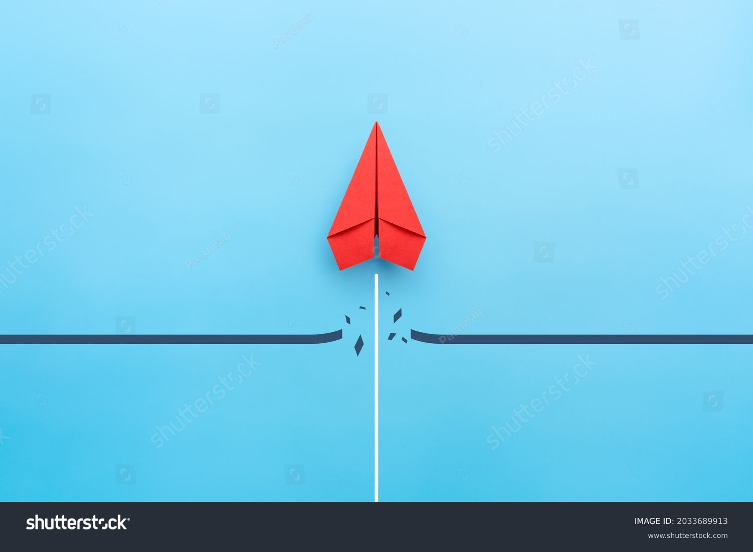 Red paper plane breaking through obstacle on blue background, Concept of overcoming barriers, goal, target #2033689913