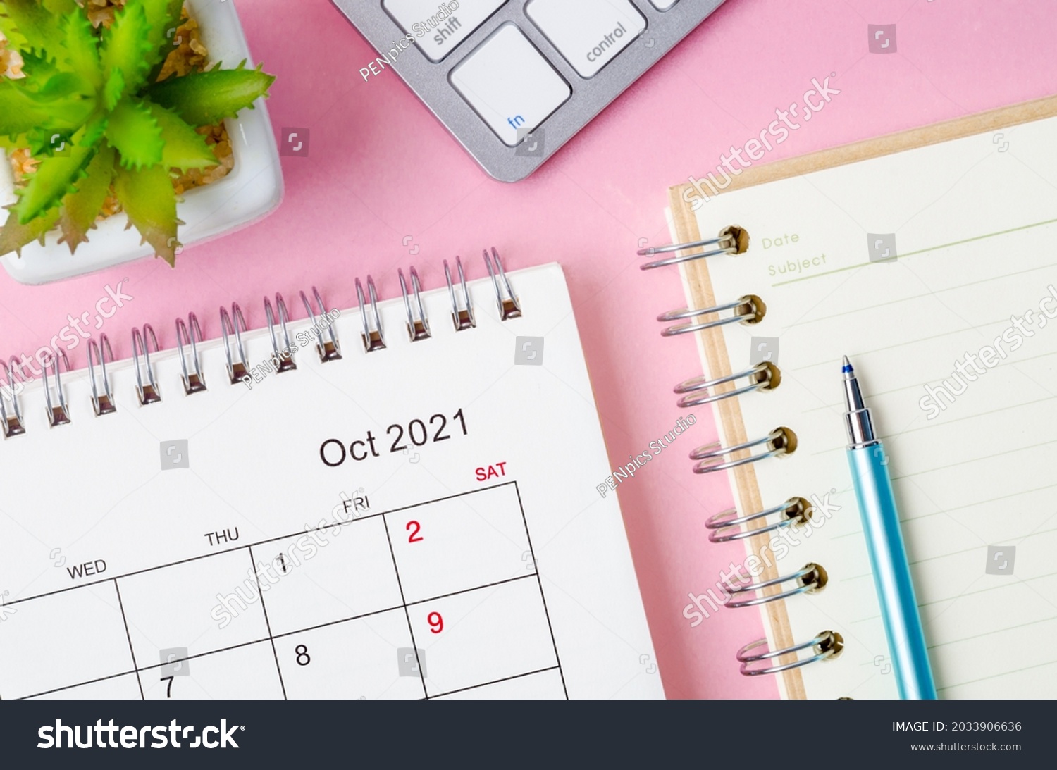 October 2021 desk calendar with keyboard computer on pink background. #2033906636