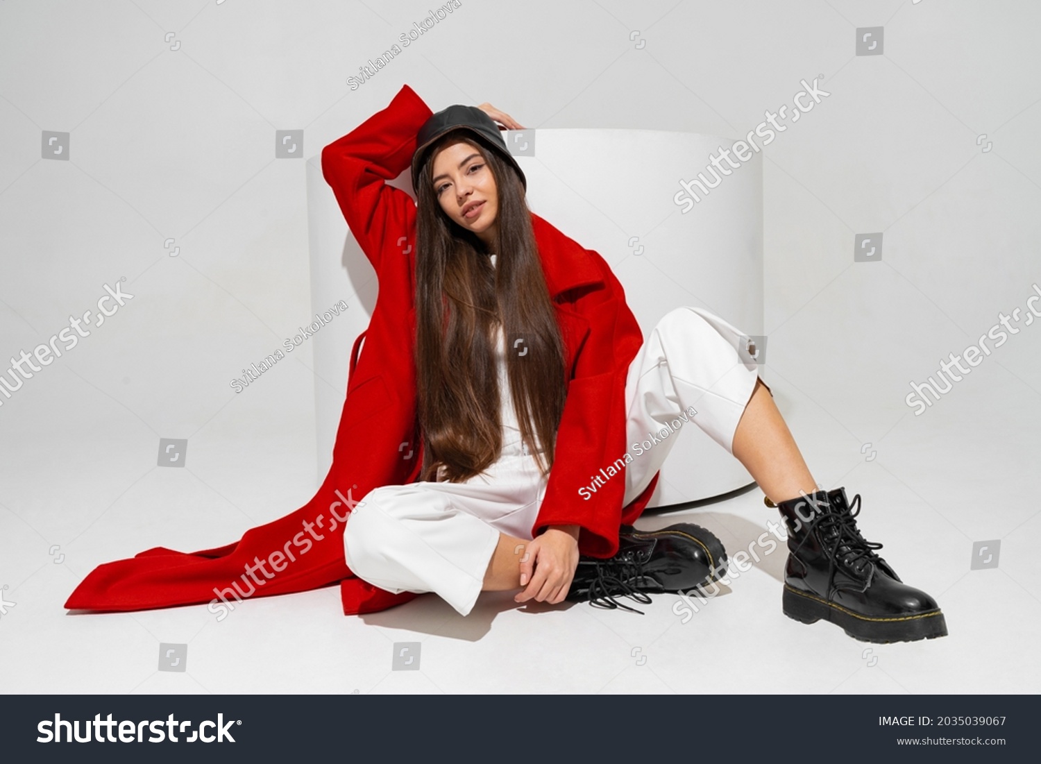 Fashionable  model in stylish  hat, red coat and boots  posing on white background in studio.   #2035039067