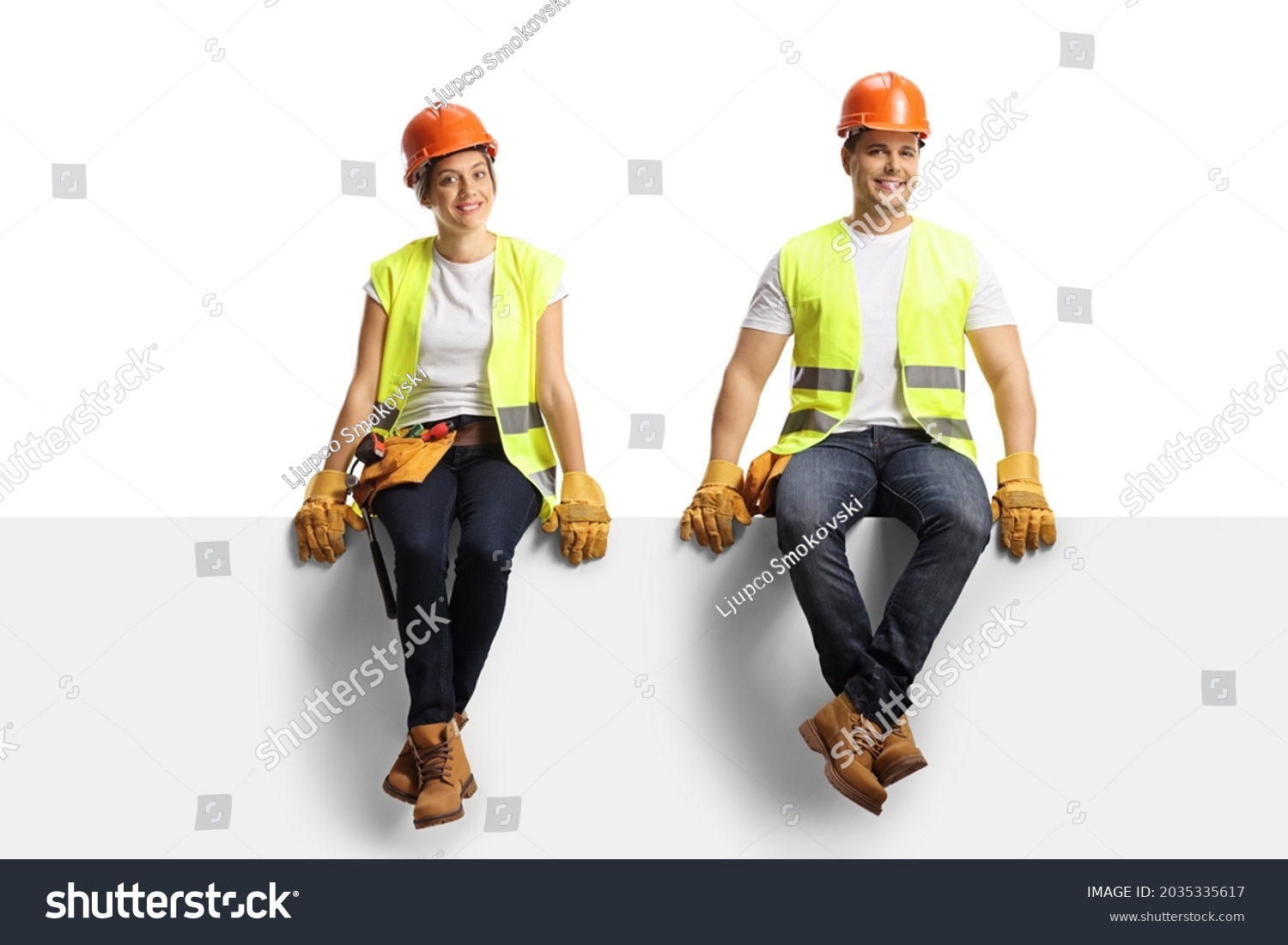 Male and female construction workers sitting on a panel and smiling at camera isolated on white background #2035335617