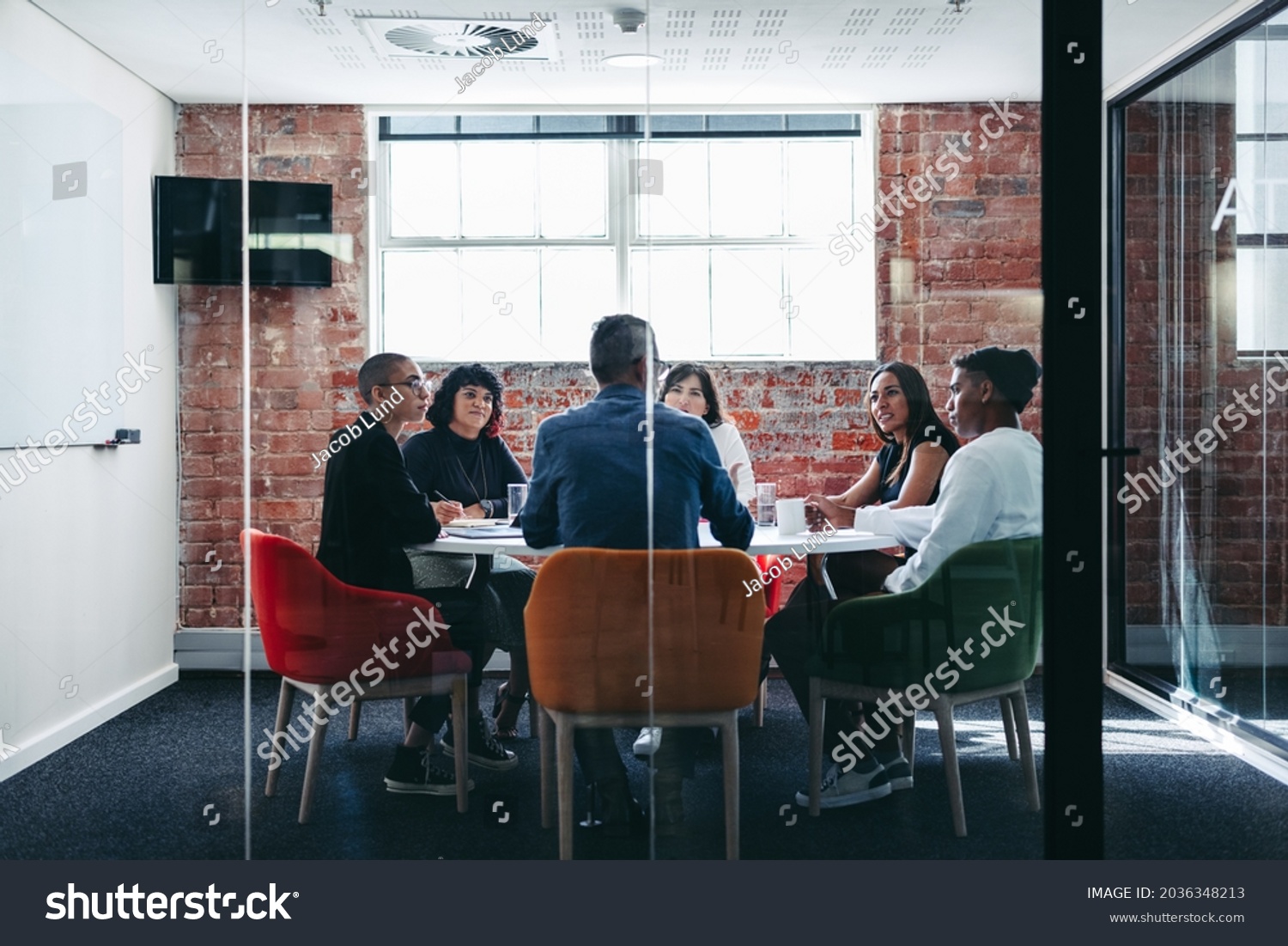 Businesspeople attending their morning briefing in a modern office. Group of creative businesspeople having a discussion during a meeting. Businesspeople working together as a team. #2036348213