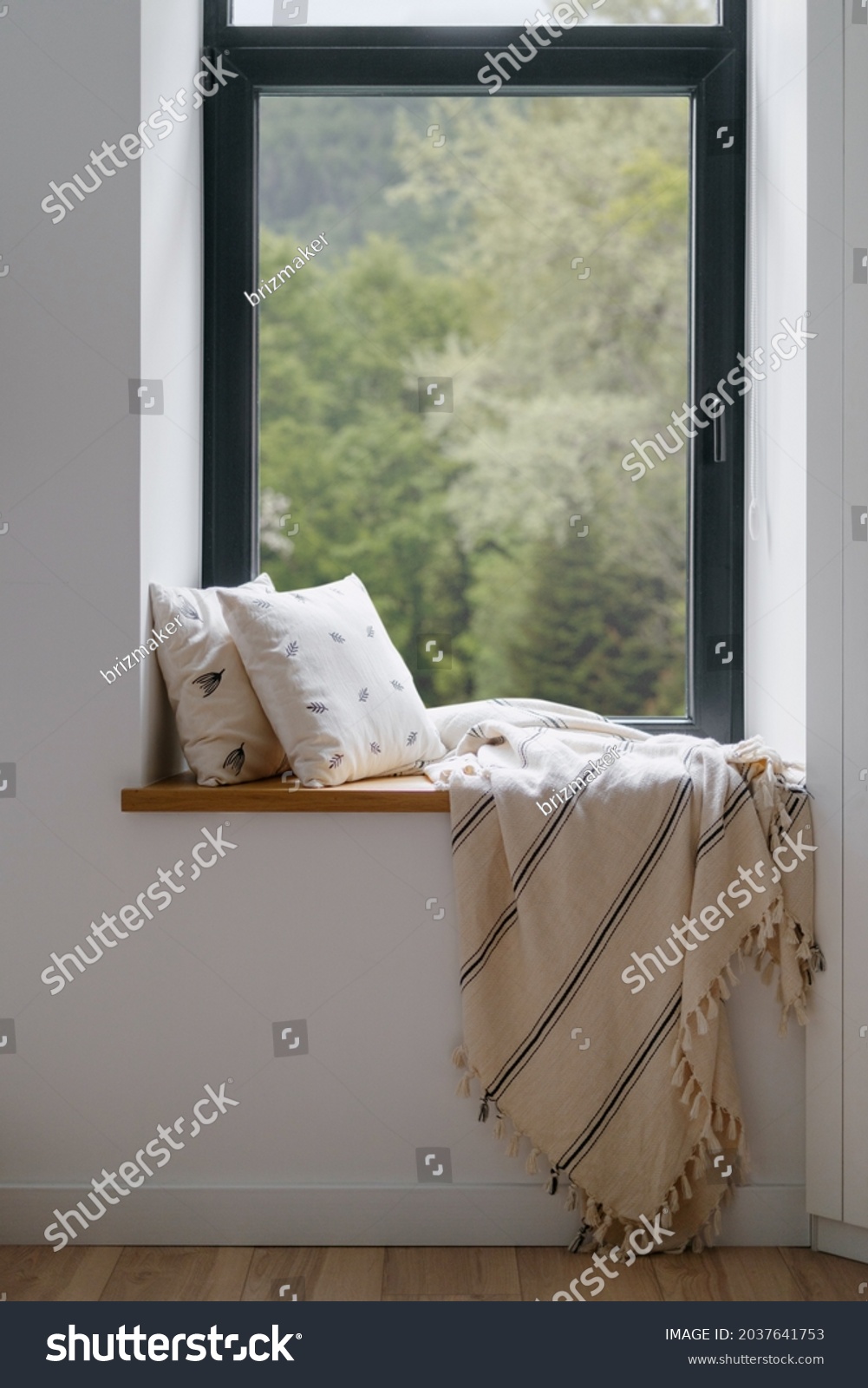 Home interior, cozy house room with blanket at window. Modern hygge design of relax place at windowsill, pillow decor for rest indoor. Nobody at comfortable sill with natural background. #2037641753