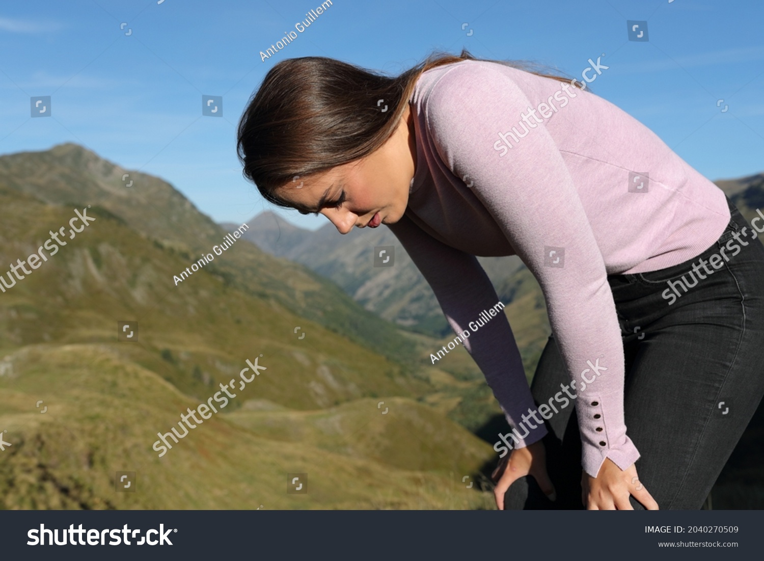 Exhausted casual woman resting after walking in the mountain #2040270509