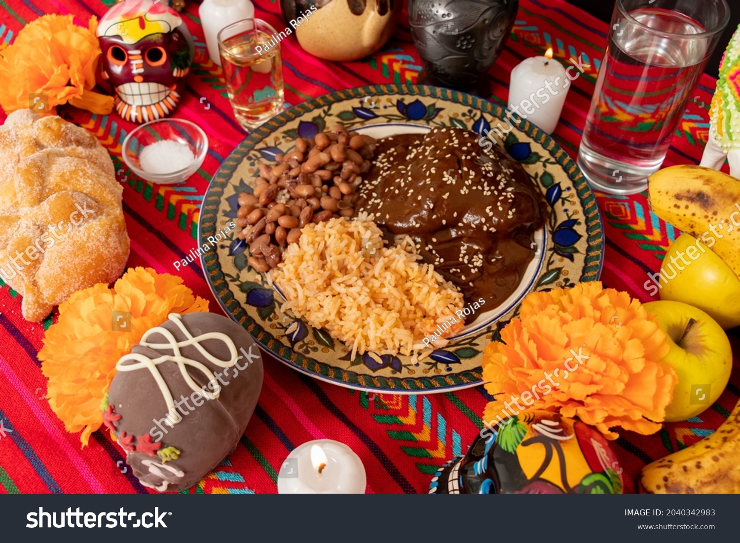 top view of an ofrenda with traditional Mexican food, alfeñique candies, fruit, candles, flowers and chocolate skulls for the Day of the Dead. #2040342983