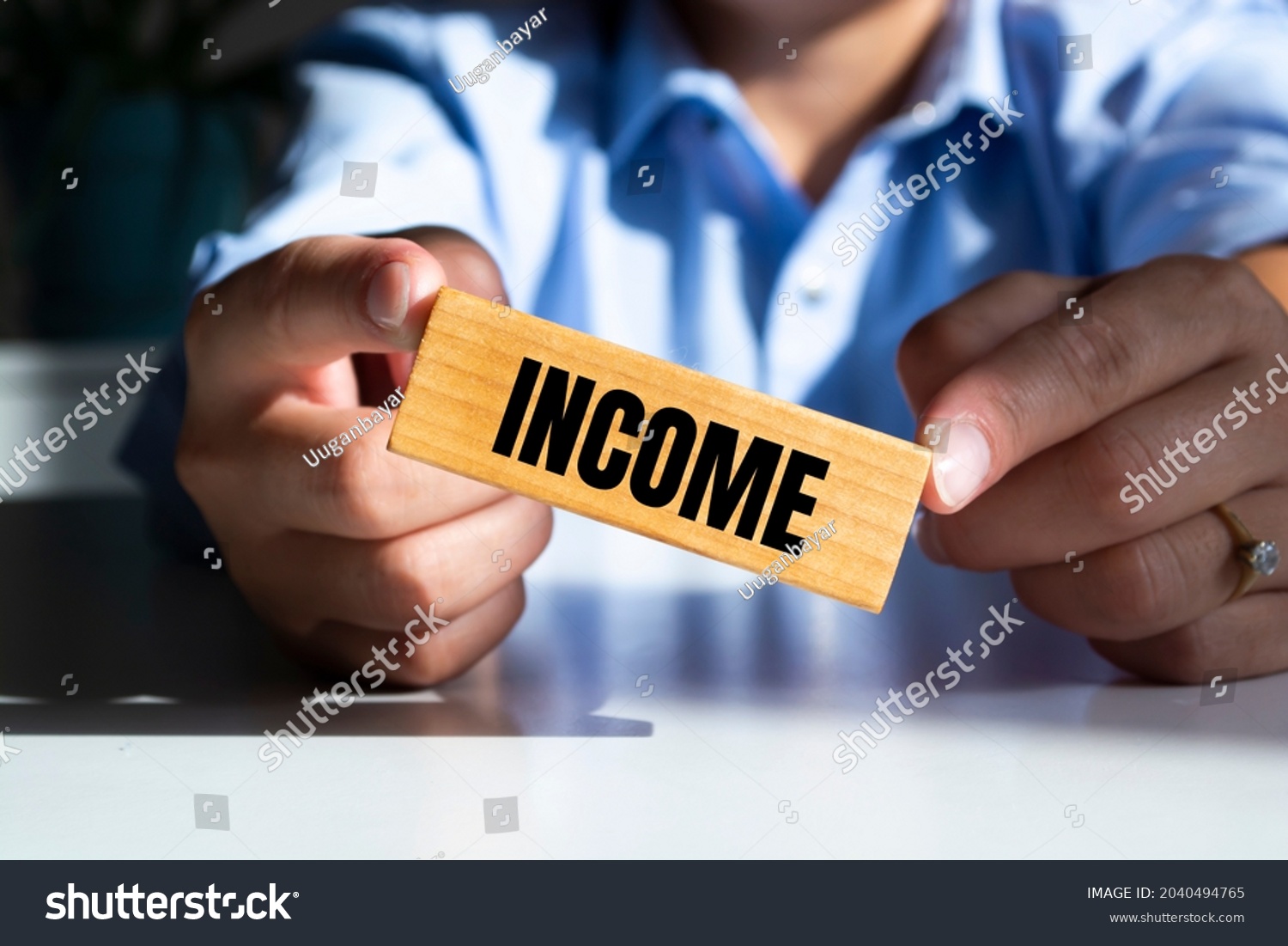Businessman puts wooden blocks with the word Income. Funds that an individual or legal entity receives during a certain period. Profit or budget of the company. Accumulation of capital #2040494765