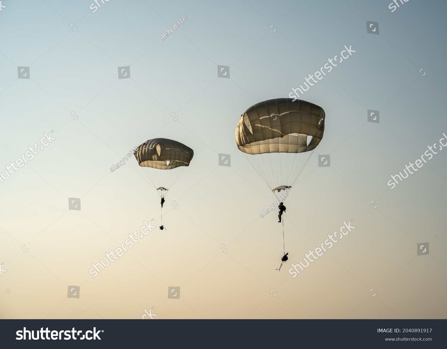 United States Army Soldiers and Paratroopers descending in the sky, from an Air Force C-130 military aircraft during an Airborne Operation. #2040891917