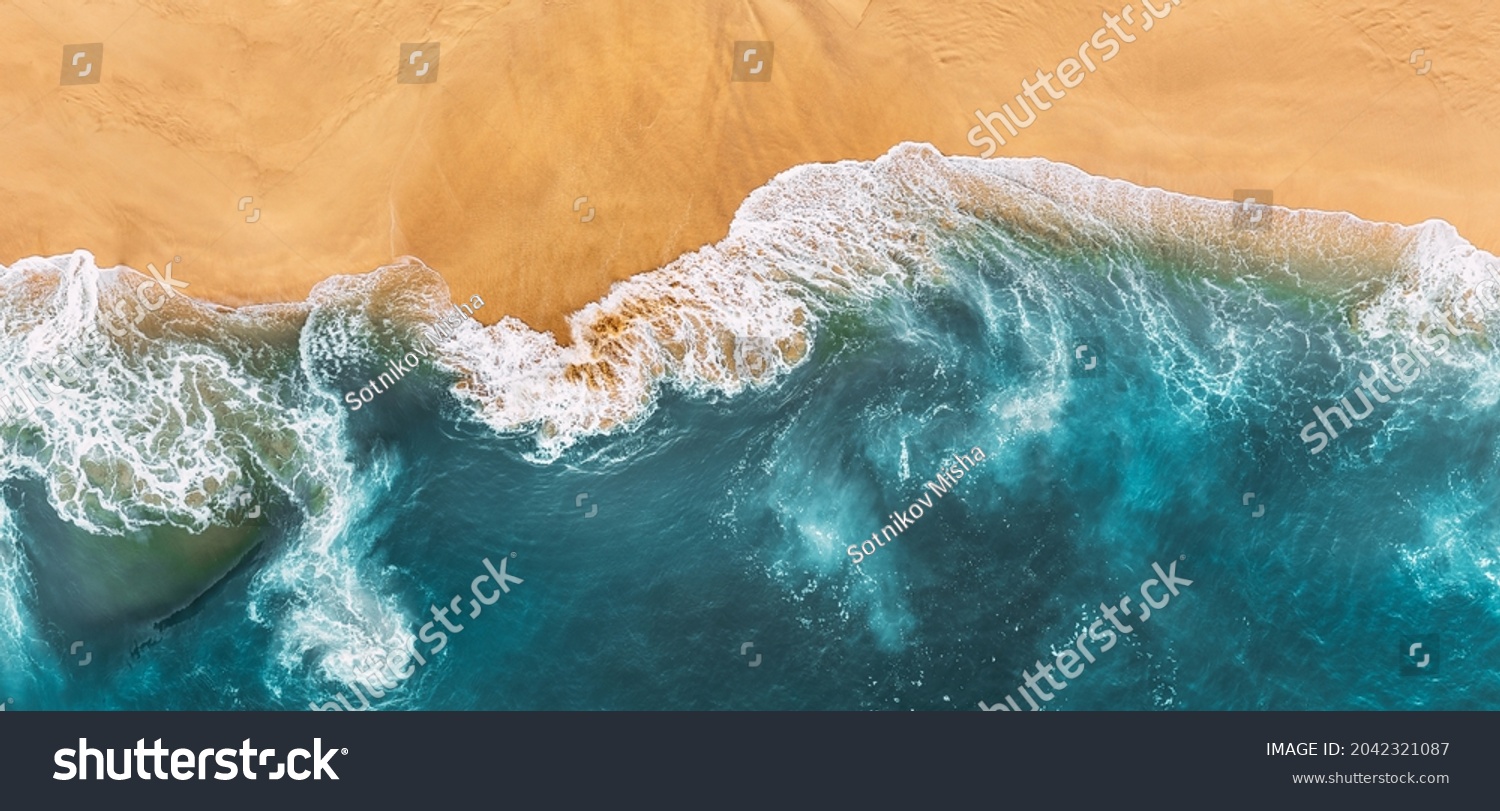 Sandy beach, panorama. Panoramic view of the sandy beach. The sea wave rolls on the shore. Sea coast view from the air. Aerial photography of the sea wave. The ocean and beach. Copy space #2042321087