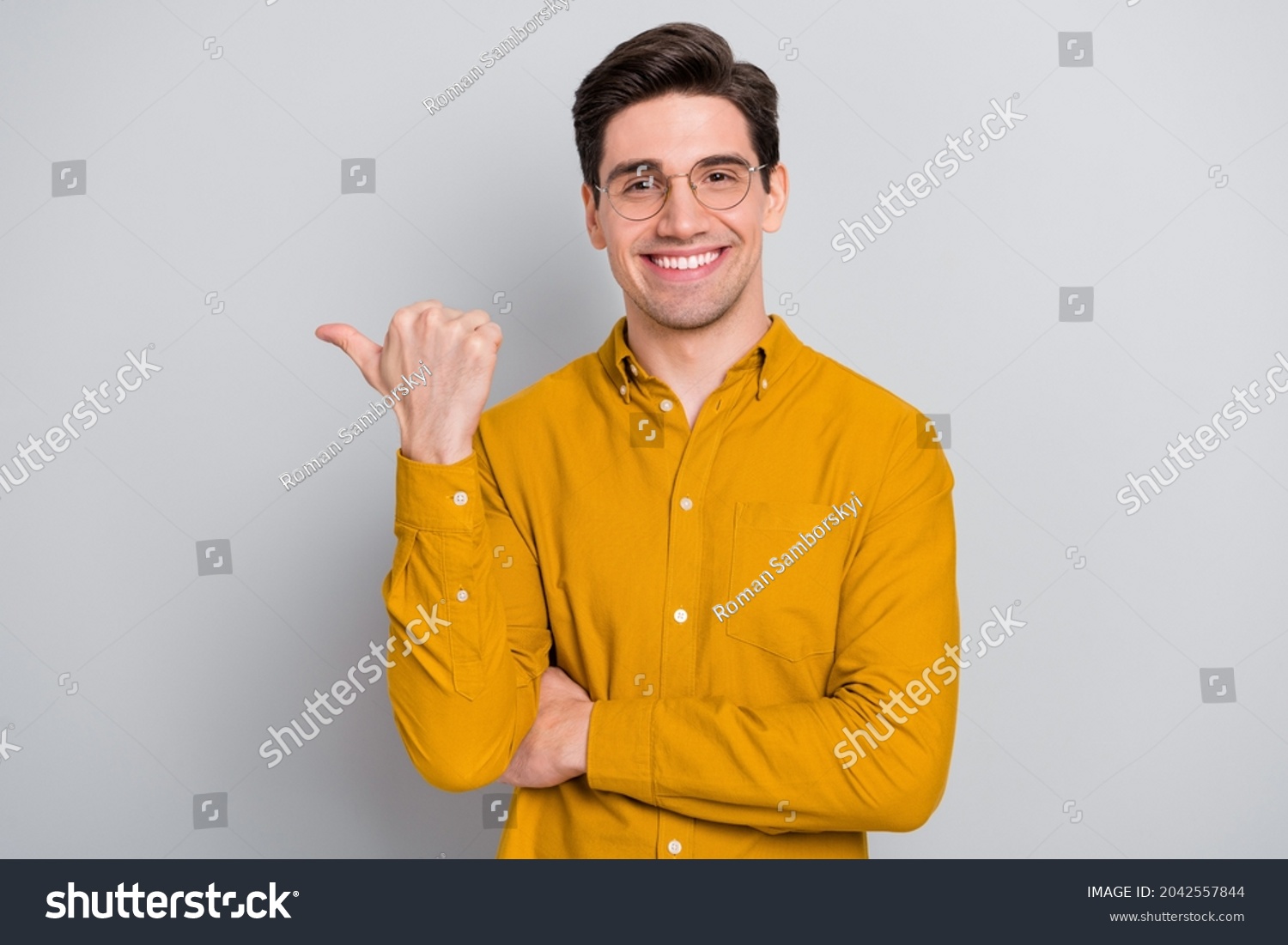 Portrait of attractive glad cheerful man manager demonstrating ad copy space isolated over grey color background #2042557844