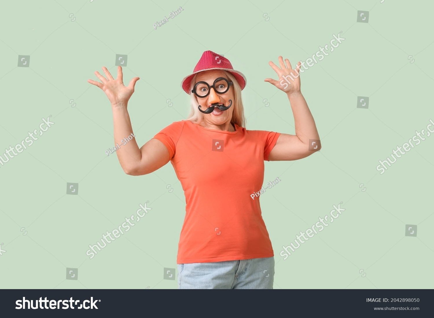 Mature woman in funny disguise on color background. April Fools Day celebration #2042898050