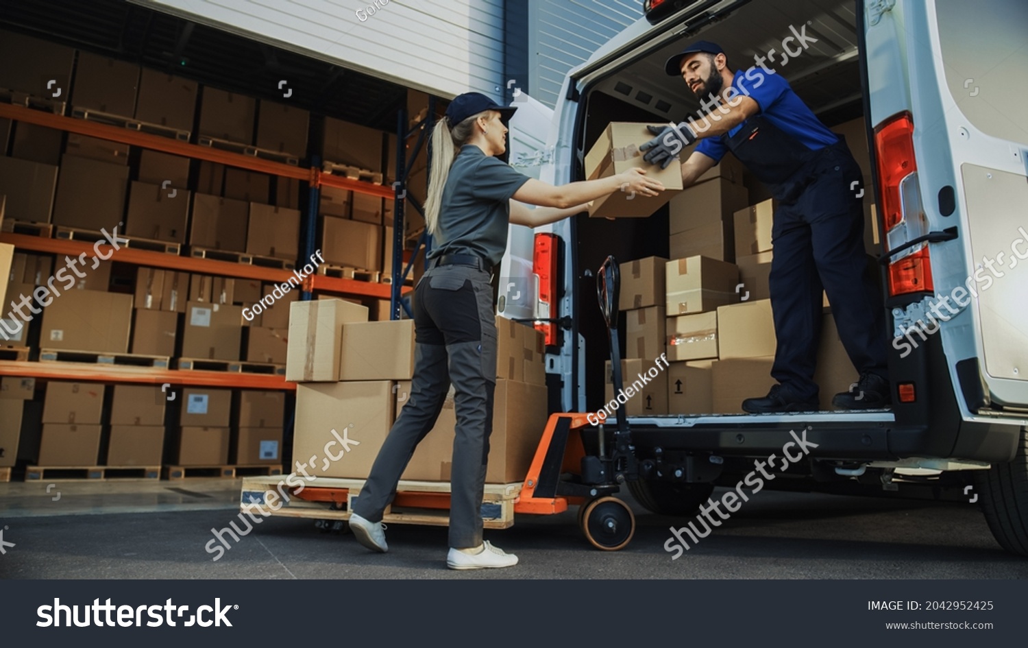 Outside of Logistics Distributions Warehouse: Diverse Team of Workers use Hand Truck Loading Delivery Van with Cardboard Boxes, Online Orders,  E-Commerce Purchases. #2042952425